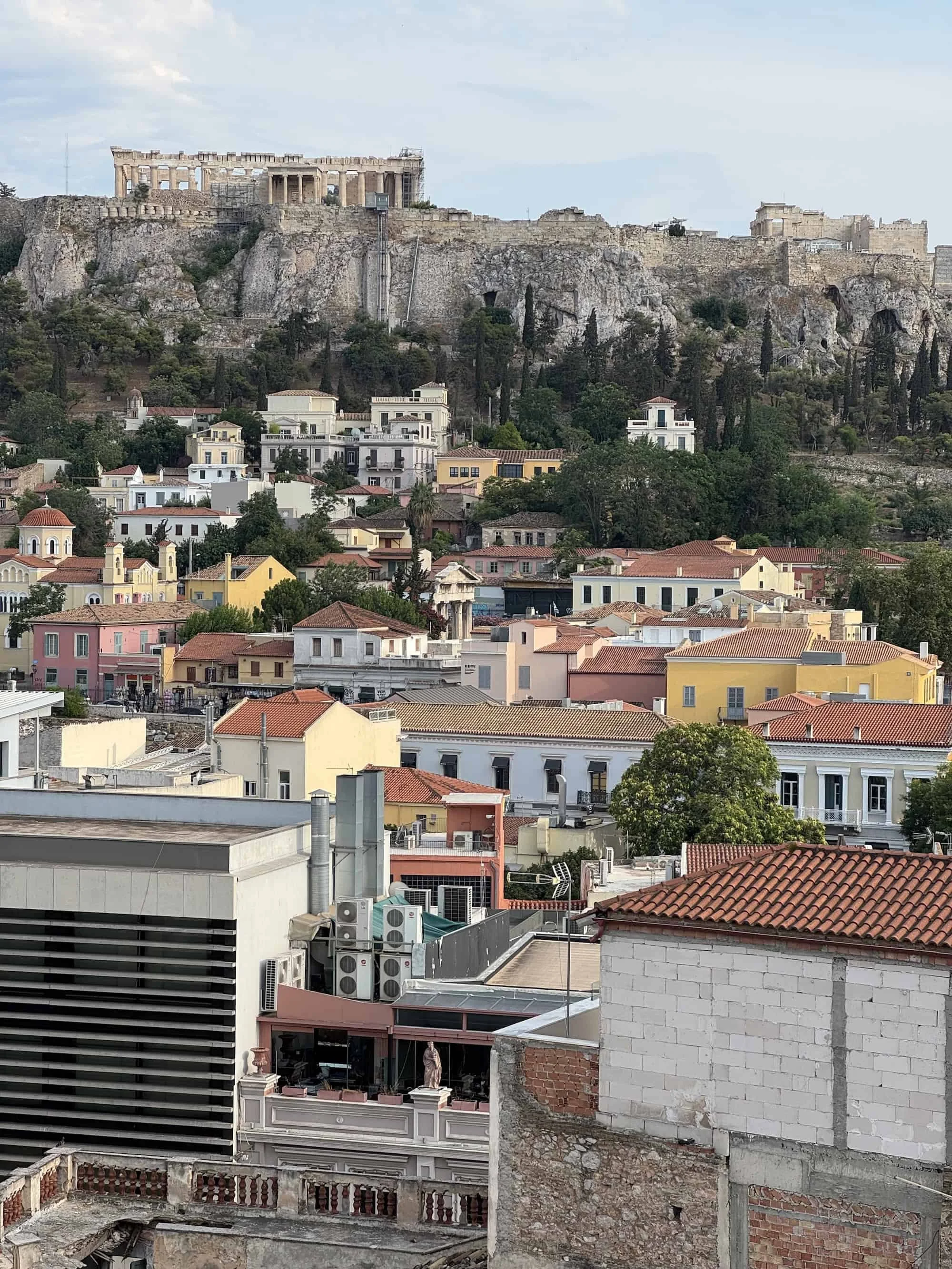 Elevated view of colorful rooftops and the Acropolis in the distance, a stunning panorama that captures the heart of what to do in Athens for first-time visitors.
