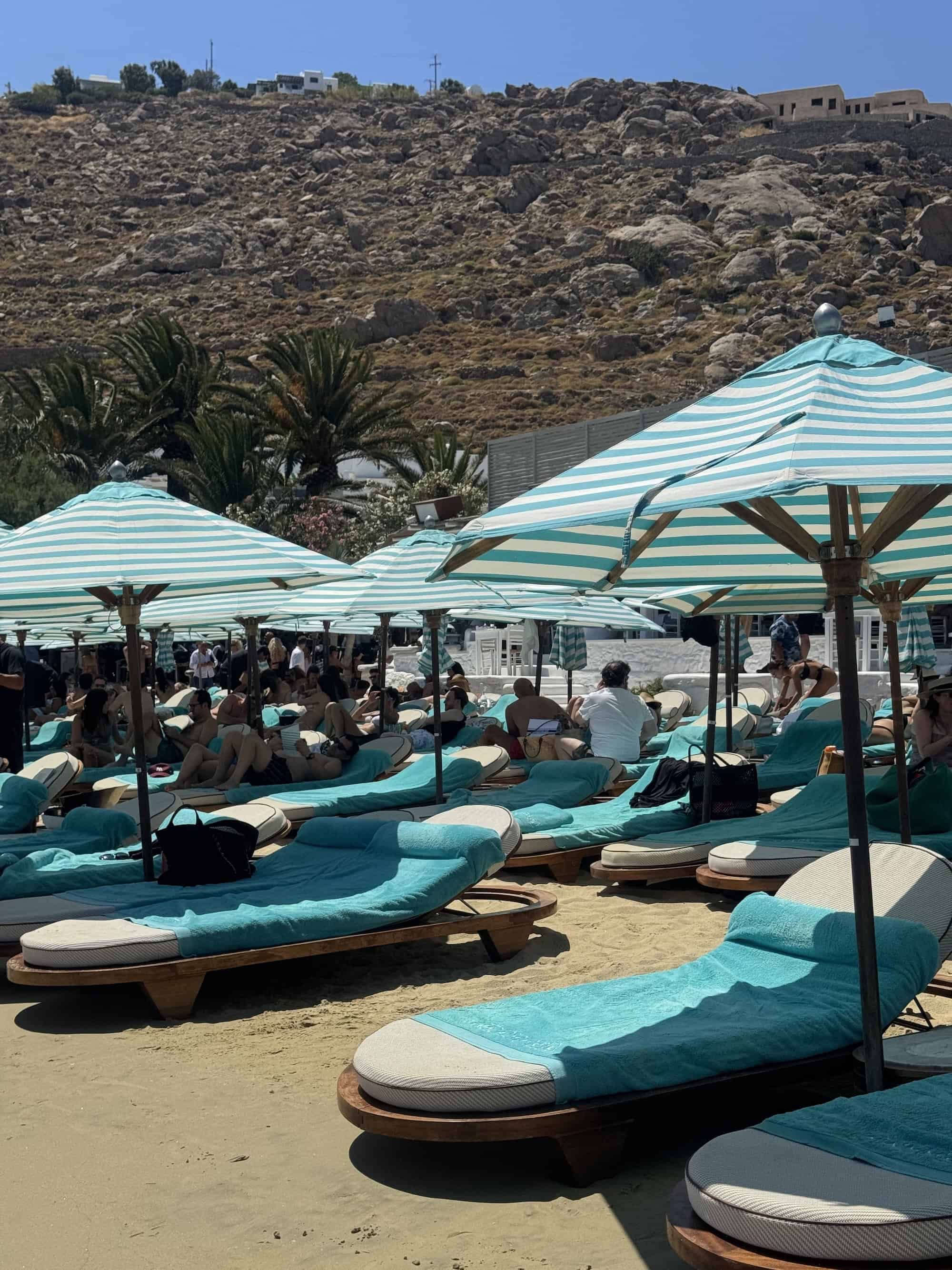 Sunbeds and striped umbrellas at Nammos Beach Club in Mykonos, a must-visit stop on a 3-day Mykonos beach club itinerary