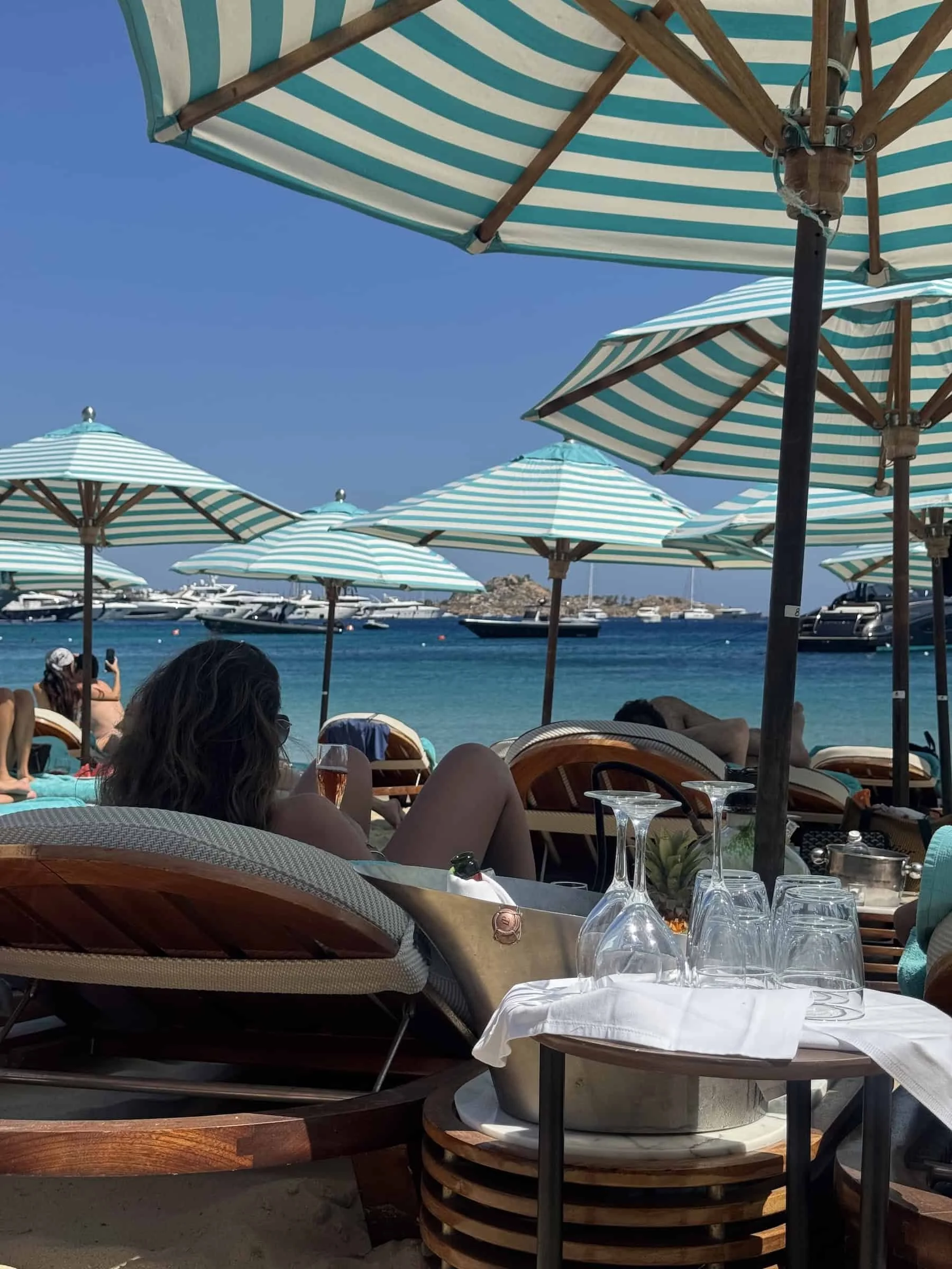 Sunbeds and striped umbrellas at Nammos Beach Club in Mykonos, a must-visit stop on a 3-day Mykonos beach club itinerary