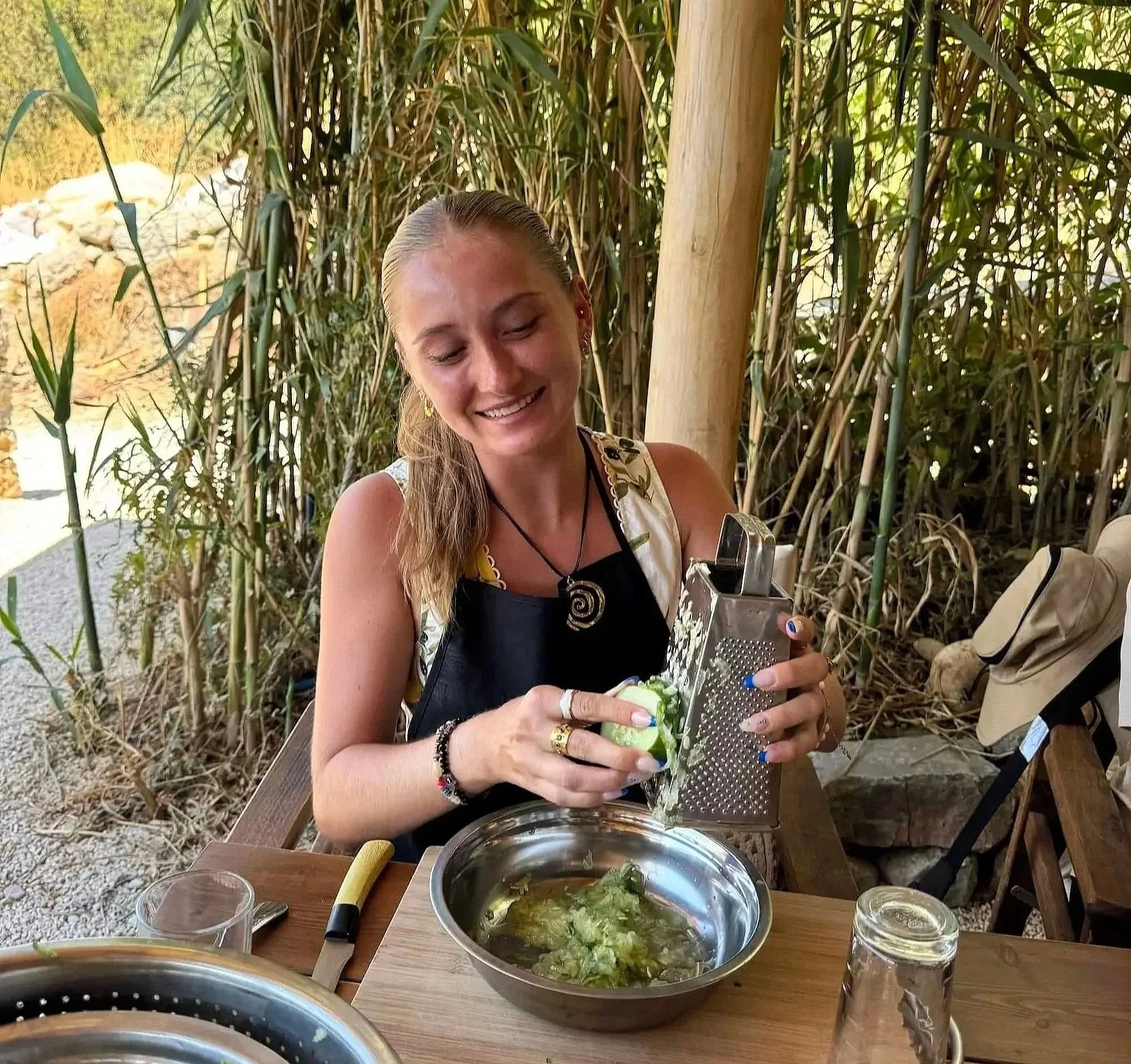 Woman grating fresh zucchini during a Perivoli Farm cooking class in Melanes, a hands-on culinary experience perfect for travelers looking for authentic things to do in Naxos.