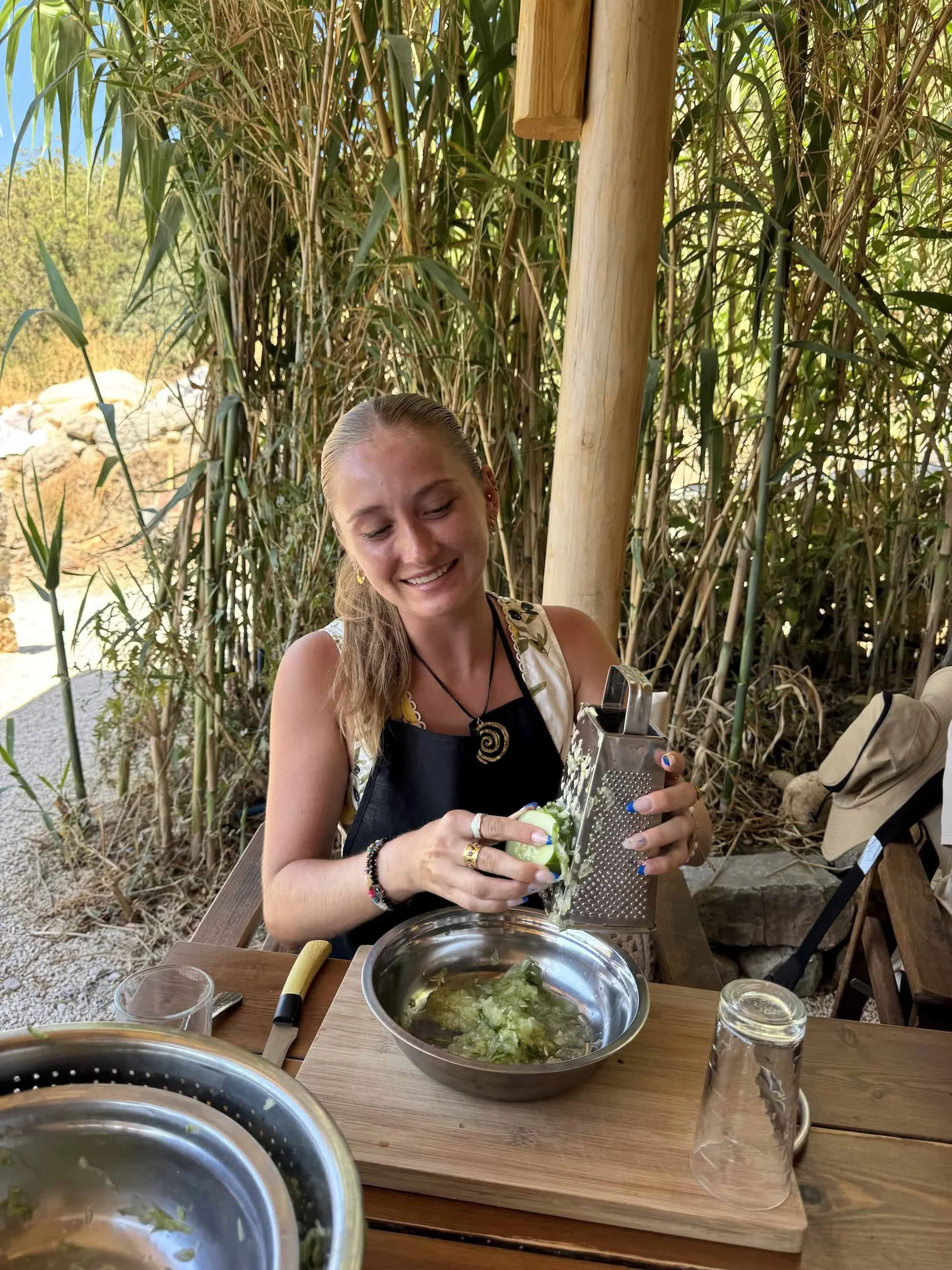 Woman grating fresh zucchini during a Perivoli Farm cooking class in Melanes, a hands-on culinary experience perfect for travelers looking for authentic things to do in Naxos.
