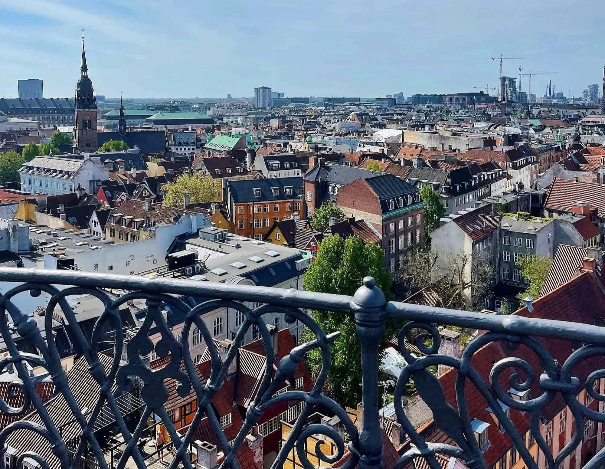 Panoramic view of Copenhagen from the Round Tower showcasing the city's historic architecture under a striking cloud pattern.