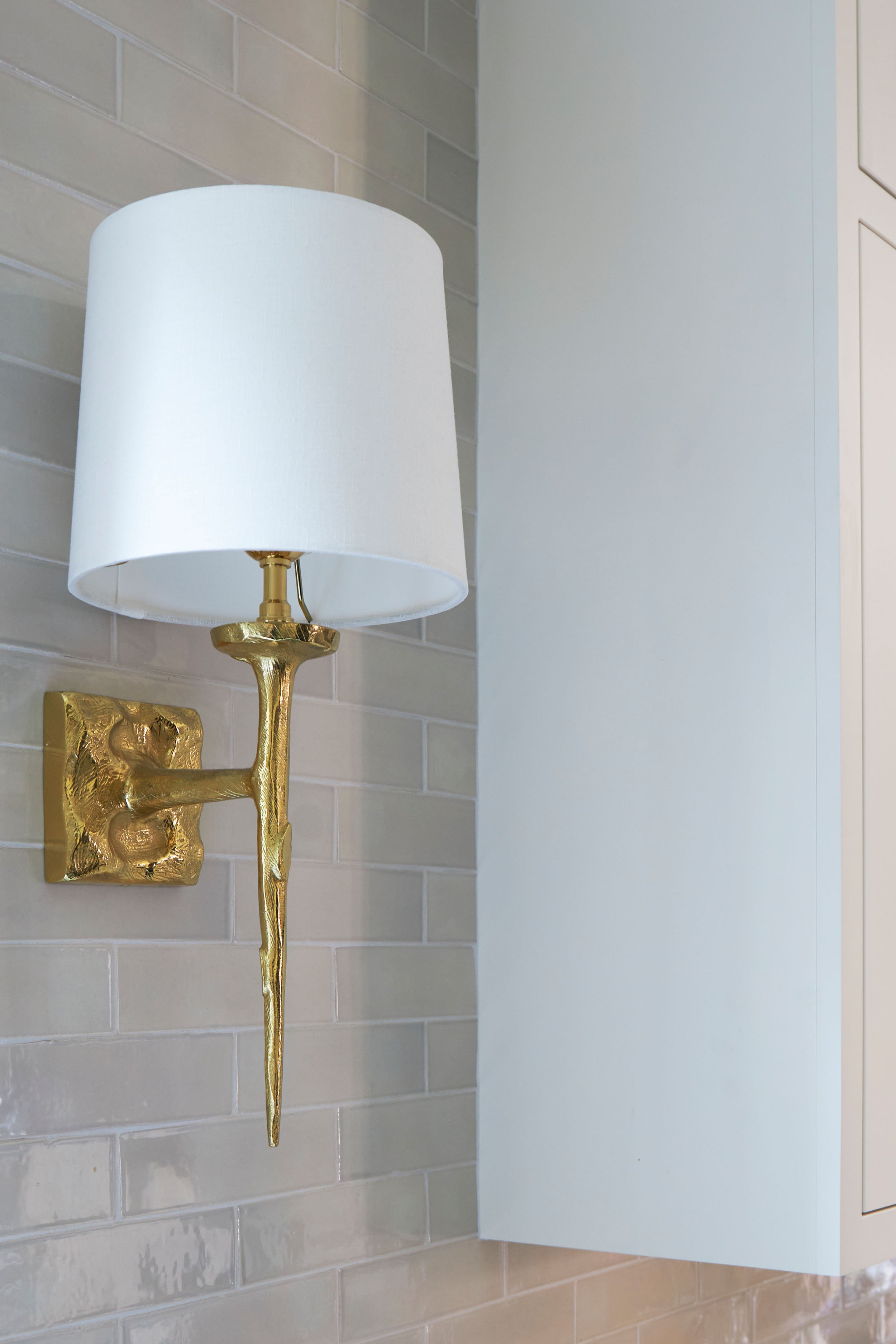 Beautiful brass sconce with lightshade on a white wall