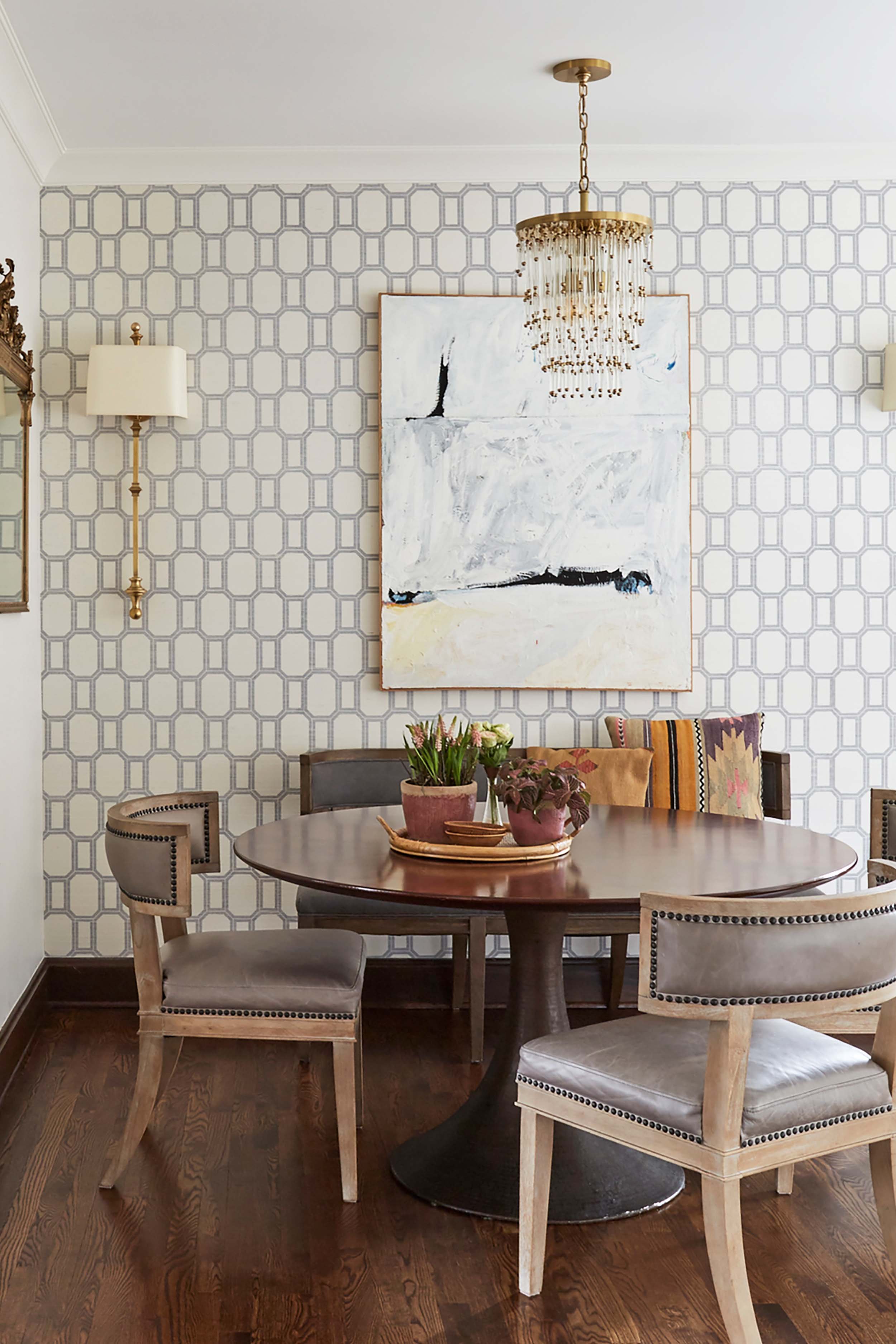 Dining nook with a chandelier, gorgeous chairs and patterned wallpaper