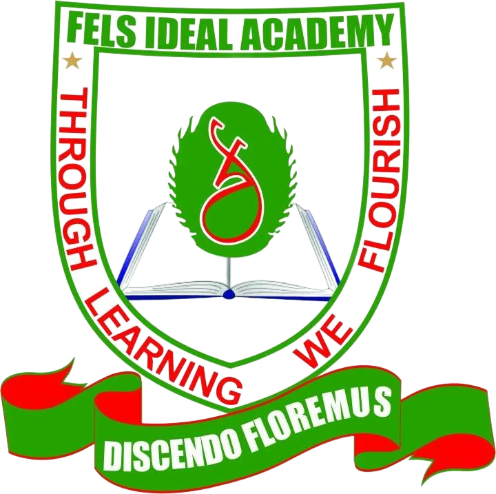 School crest for Fels Ideal Academy with a green shield, a red and white caduceus, an open book, and Latin motto 'Discendo Floremus' meaning "Through Learning We Flourish" on a green banner.