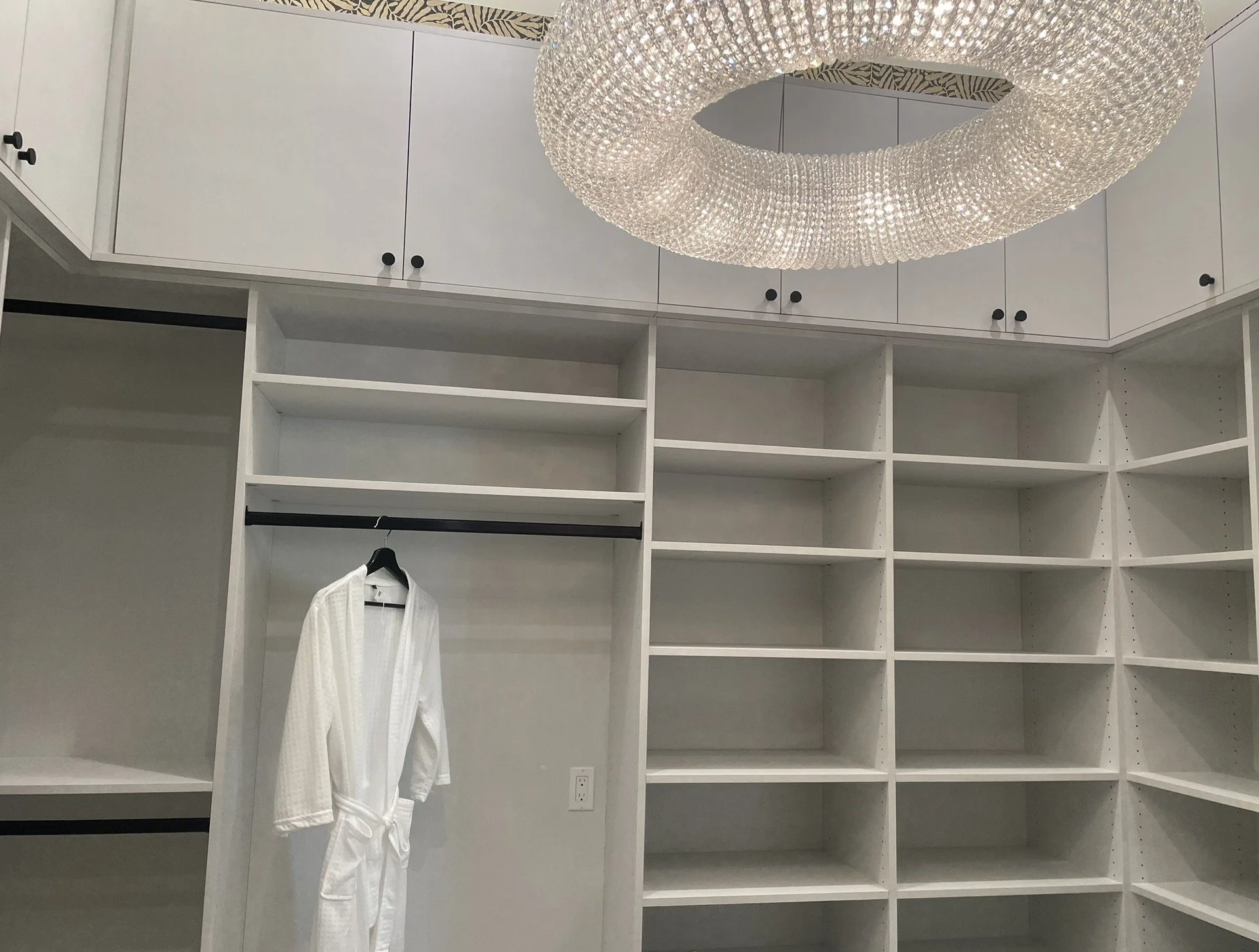 Master closet, doors above, open storage and hanging, lighting above closet