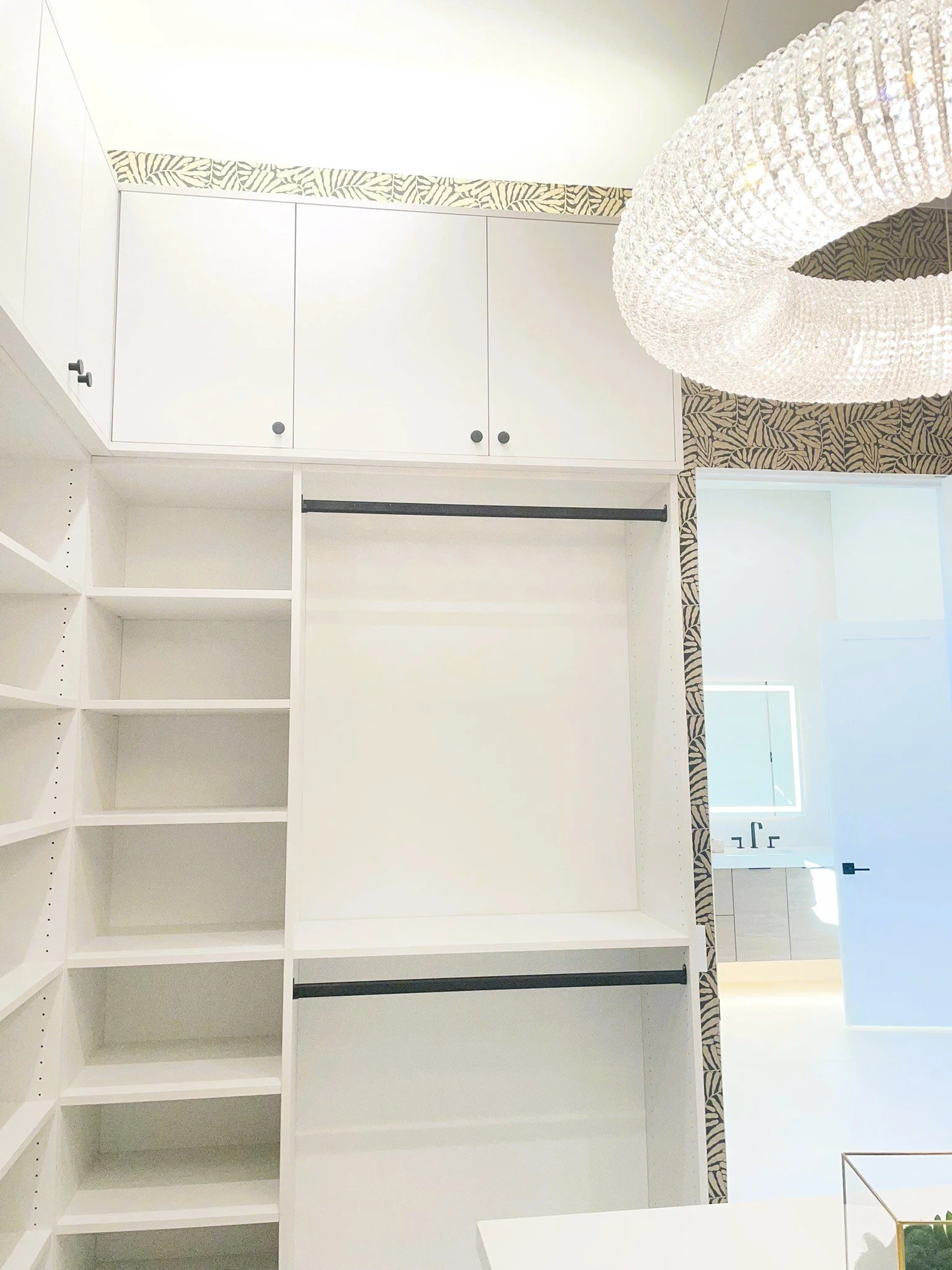 Master closet, double hang, closed doors above, integrated lighting above.  White textured linen.