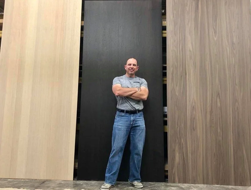 Founder Karl Baumgart selecting veneers and finished material in a shop.