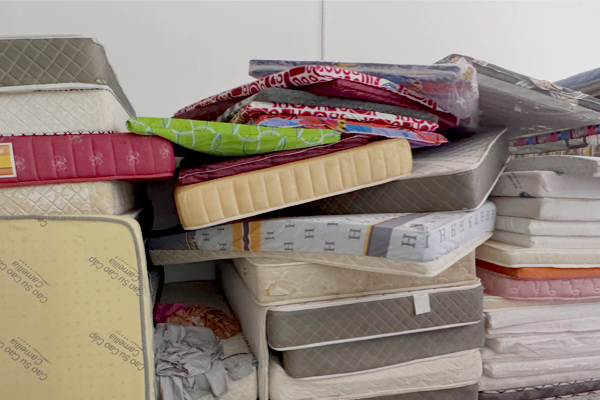 Mattresses stacked along the wall of a closed scam compound in Cambodia.