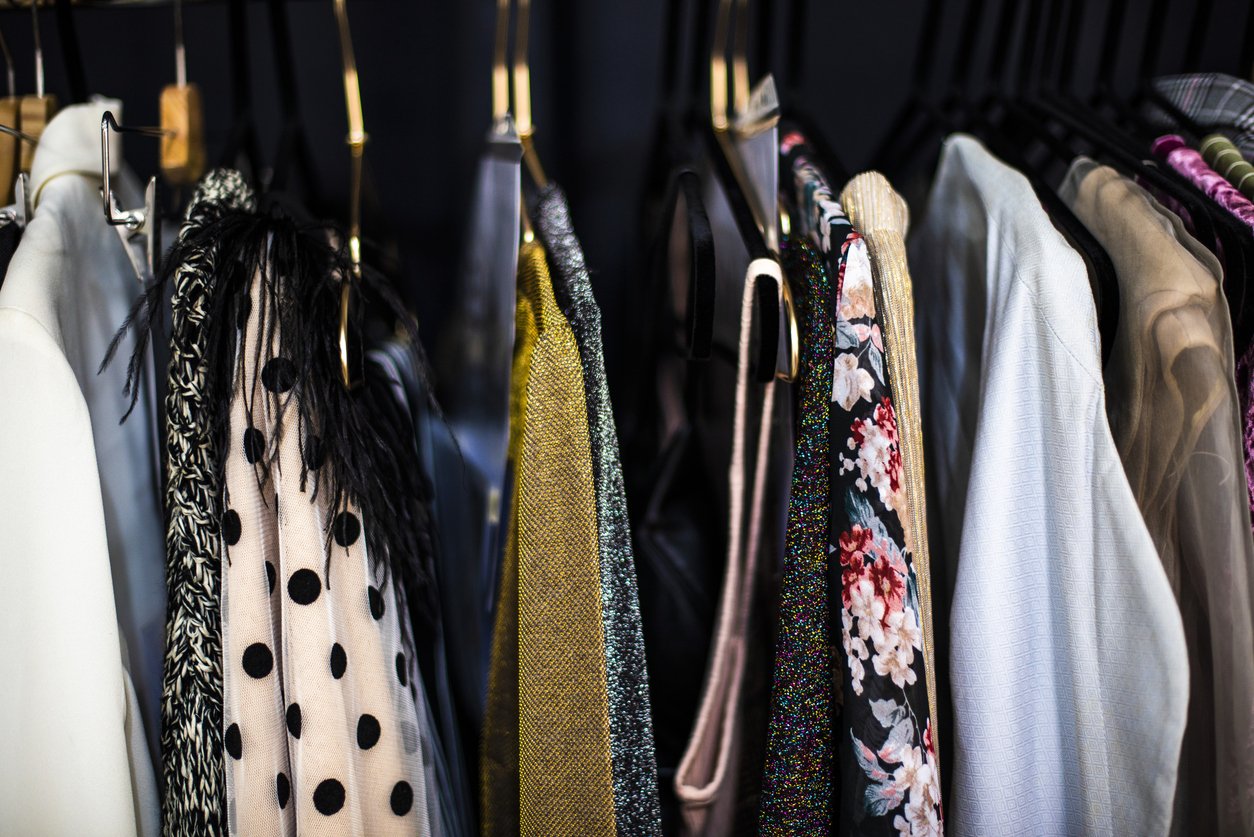 Colorful clothing and scarves hanging on a rack