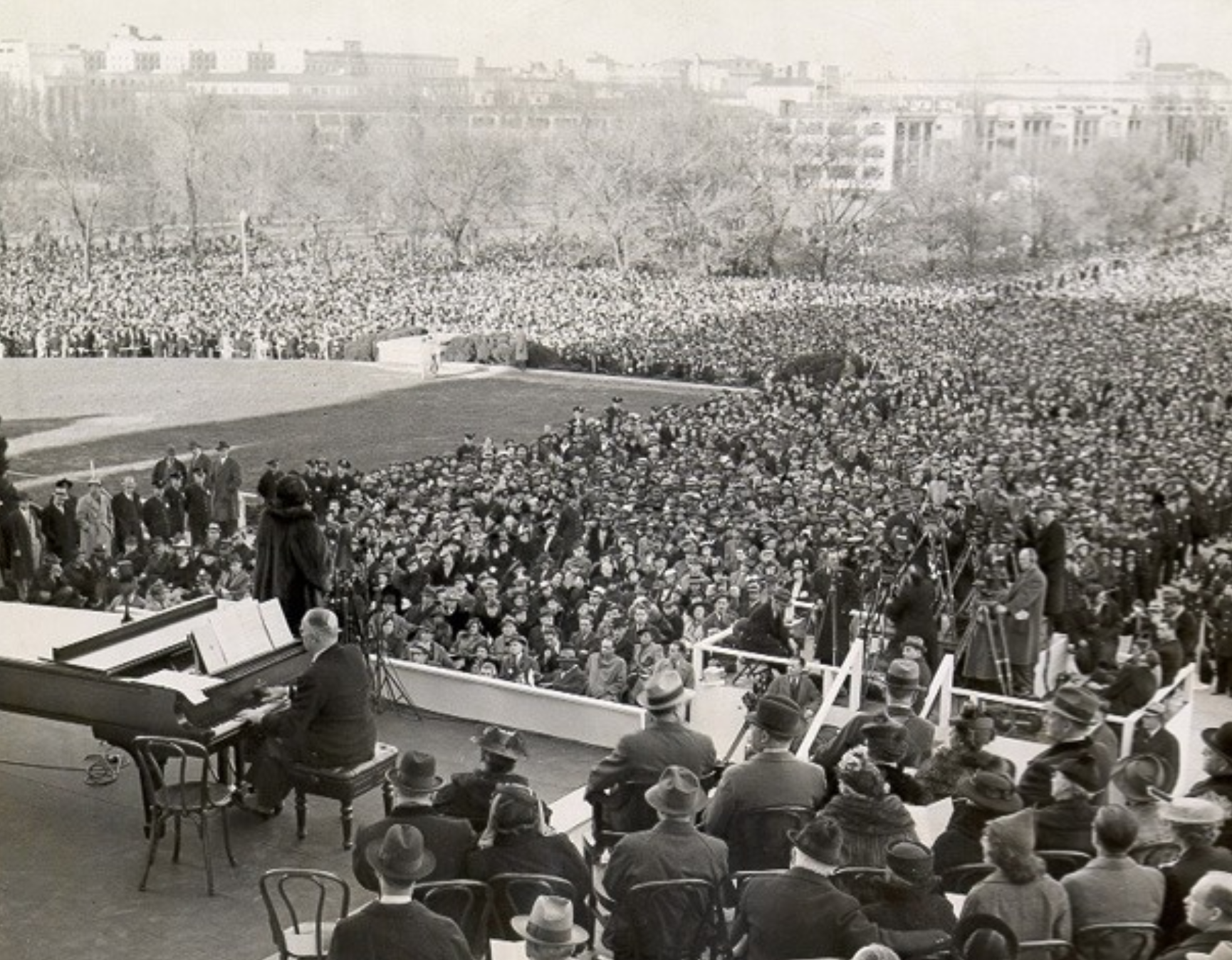 Historic black-and-white photograph of Marian Anderson and a pianist performing before a large outdoor crowd at Washington, D.C.,