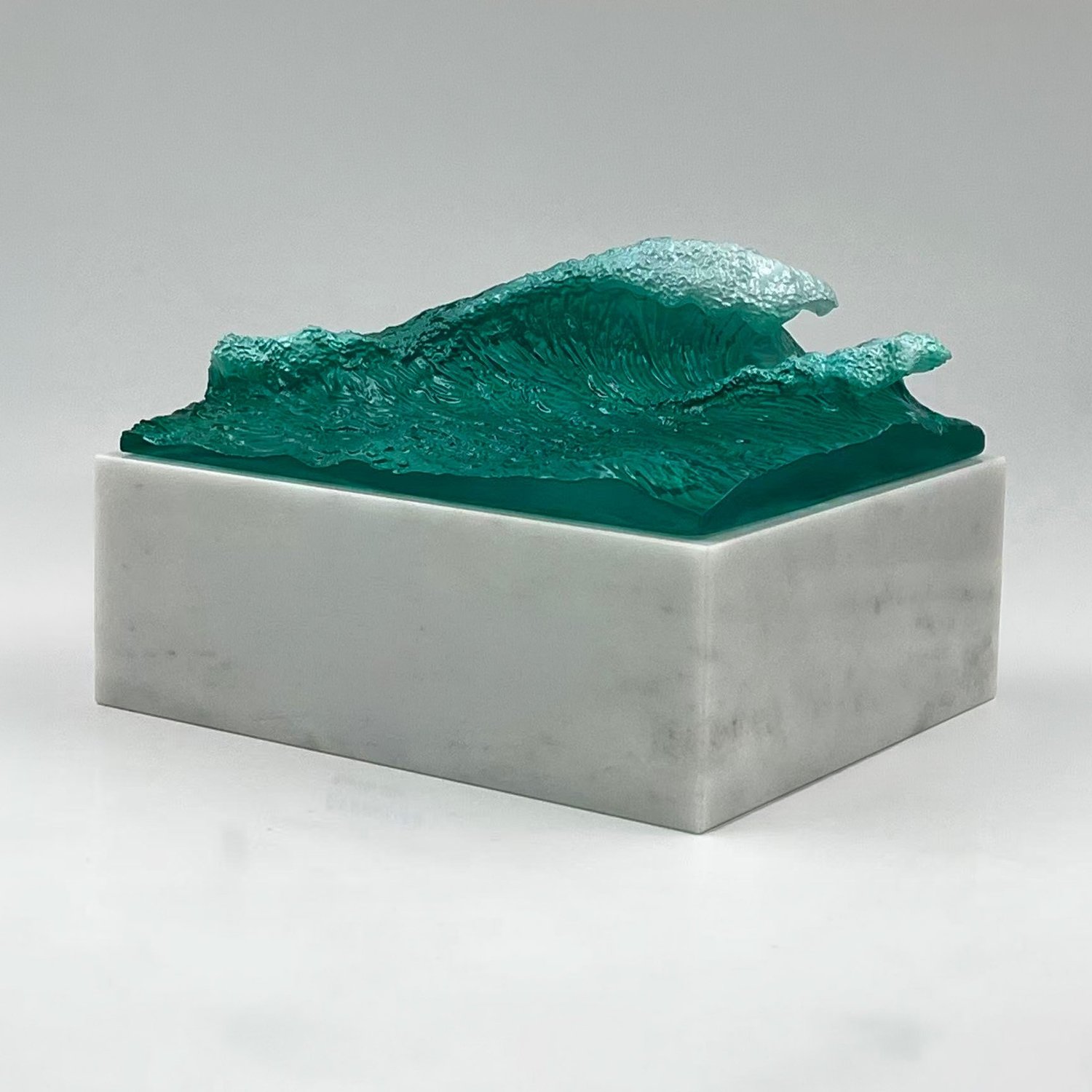 Sculptural custom award with a textured green ocean wave on a rectangular silver-colored base.