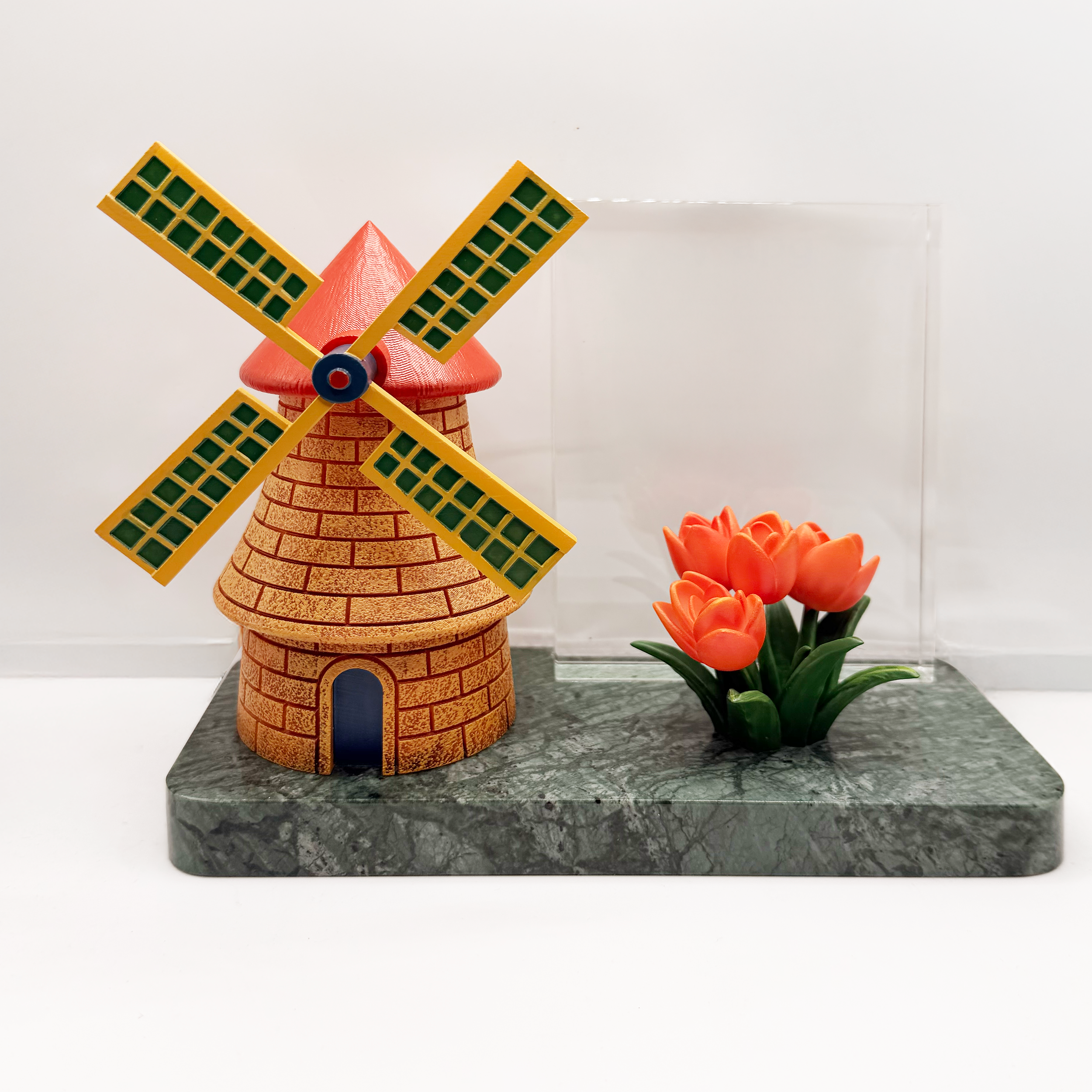 Custom Dutch windmill deal toy with spinning blades and resin tulips mounted on green marble base with crystal panel backdrop