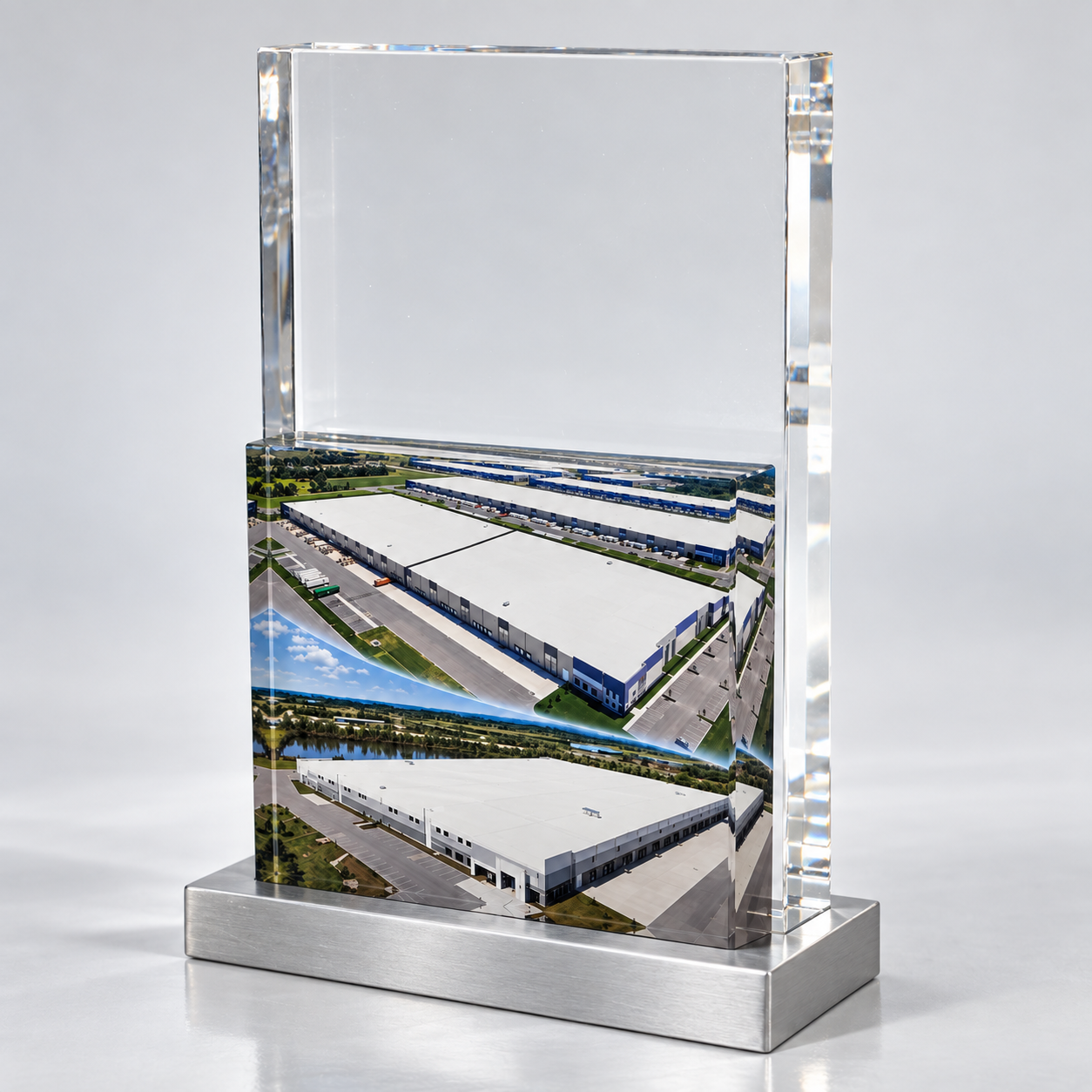 Real estate deal toy with two warehouse photographs in a clear upright panel on a silver-colored base.