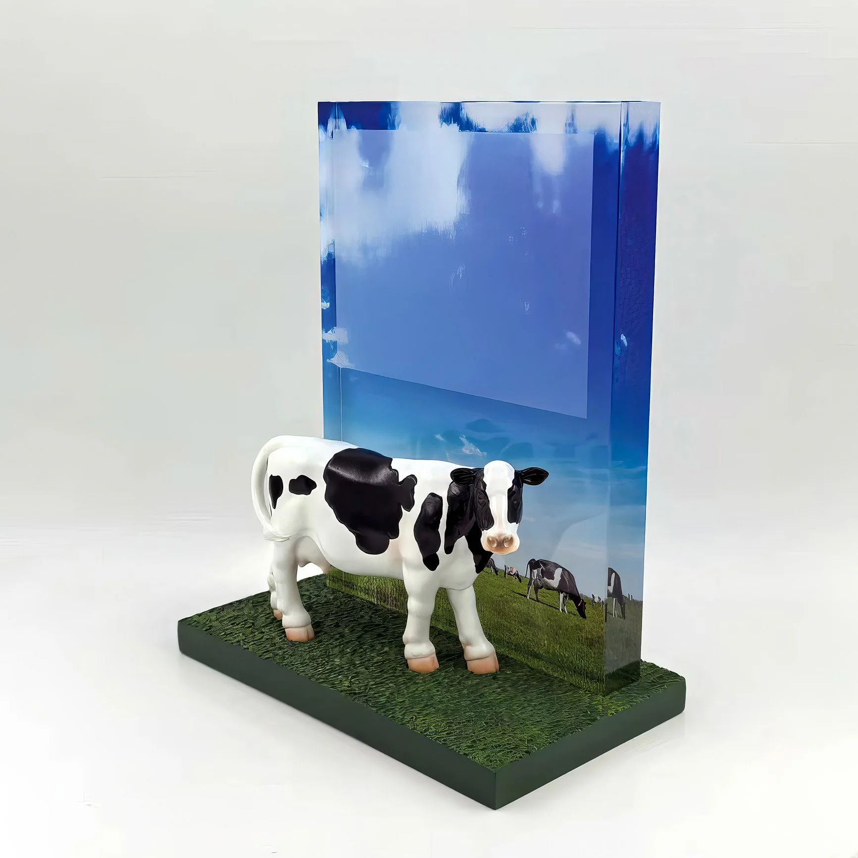 Custom dairy industry deal toy featuring a hand-painted resin Holstein cow mounted on a textured base with translucent blue acrylic.