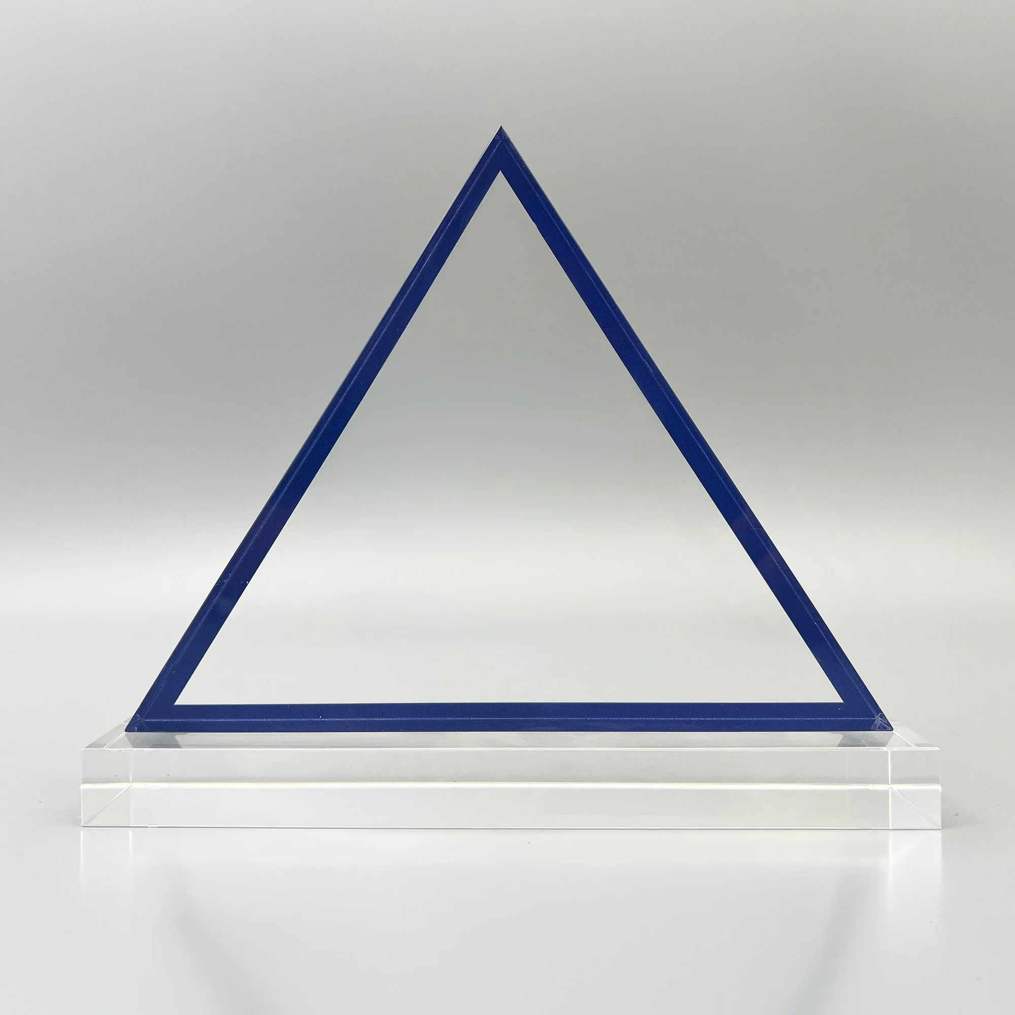 Open triangular blue Lucite corporate award mounted on a clear rectangular base.