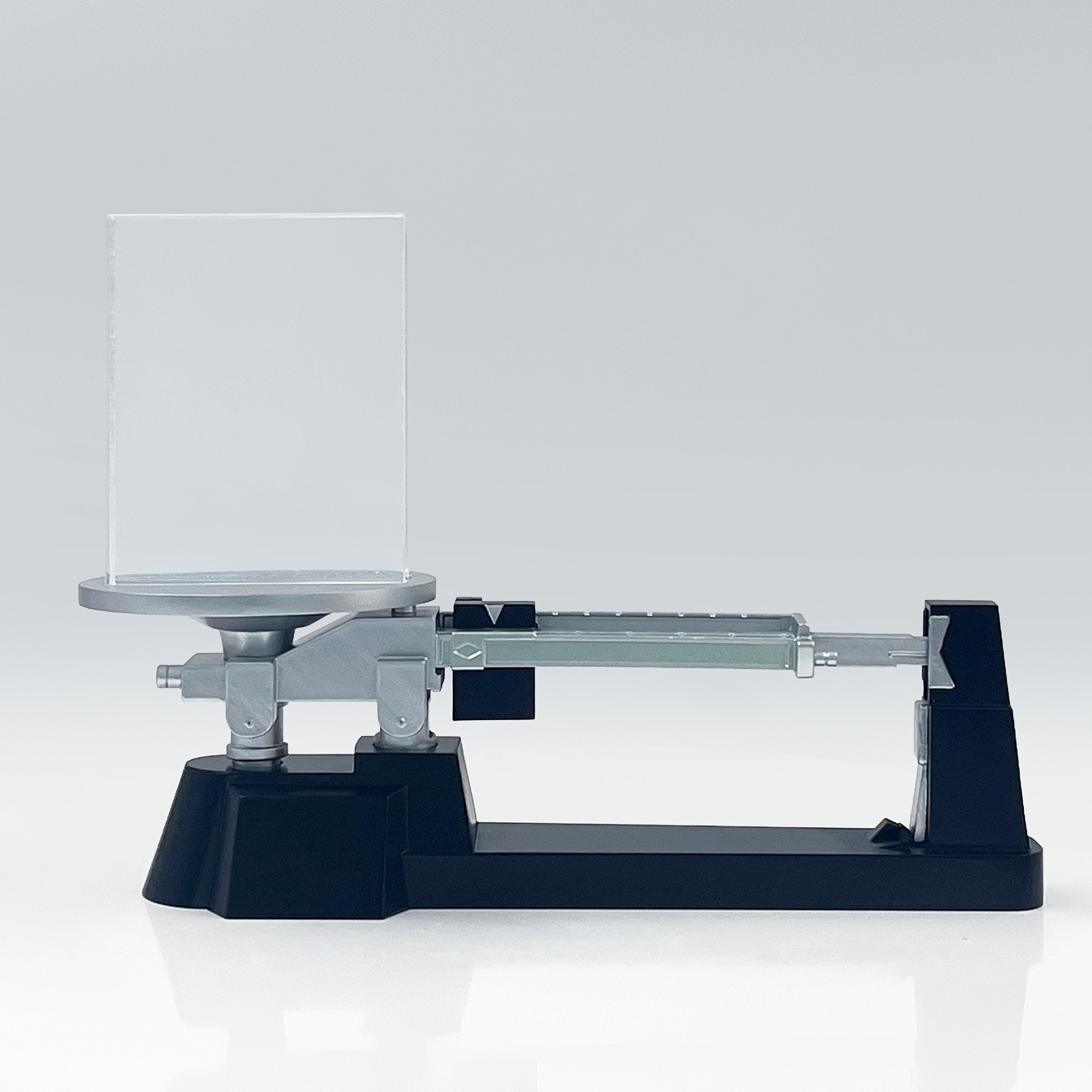 Custom industrial deal toy modeled after a mechanical balance scale with a clear inscription panel.