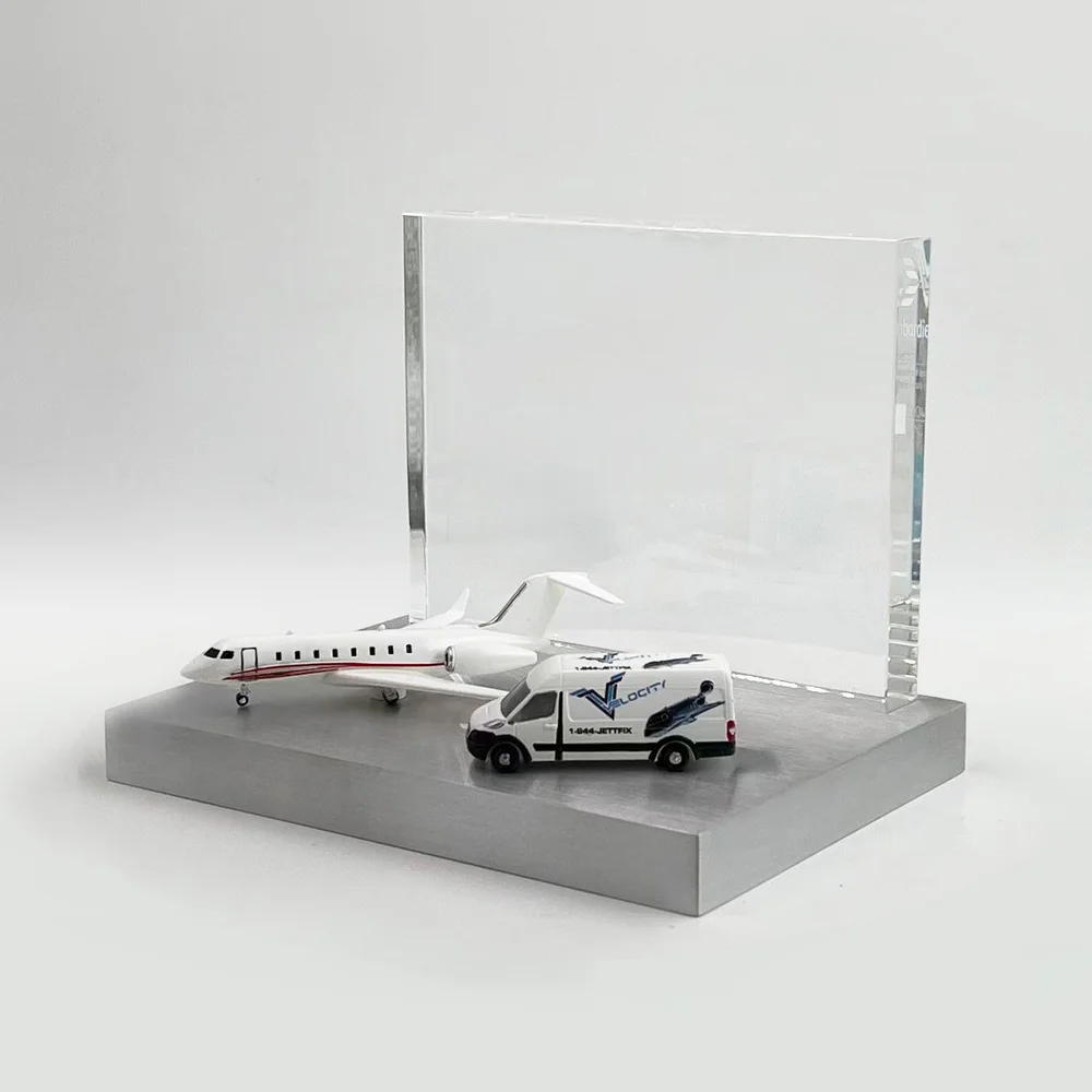 Aviation deal toy with a private jet and ground-service vehicle in front of a clear panel on a rectangular base.