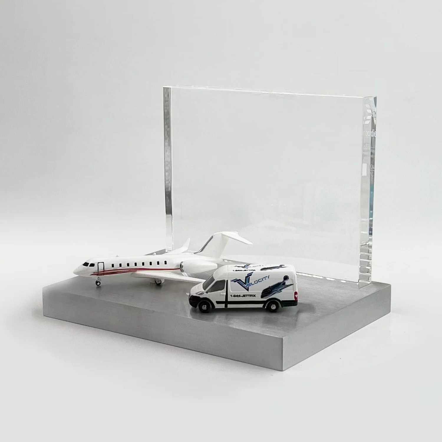 Aviation deal toy with a private jet and ground-service vehicle in front of a clear panel on a rectangular base.