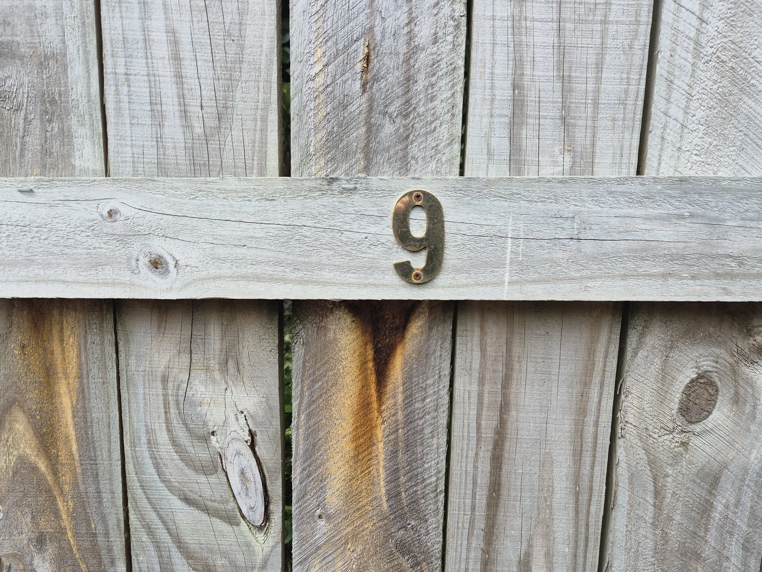 Number 9 marking the designated client parking space on the fence.