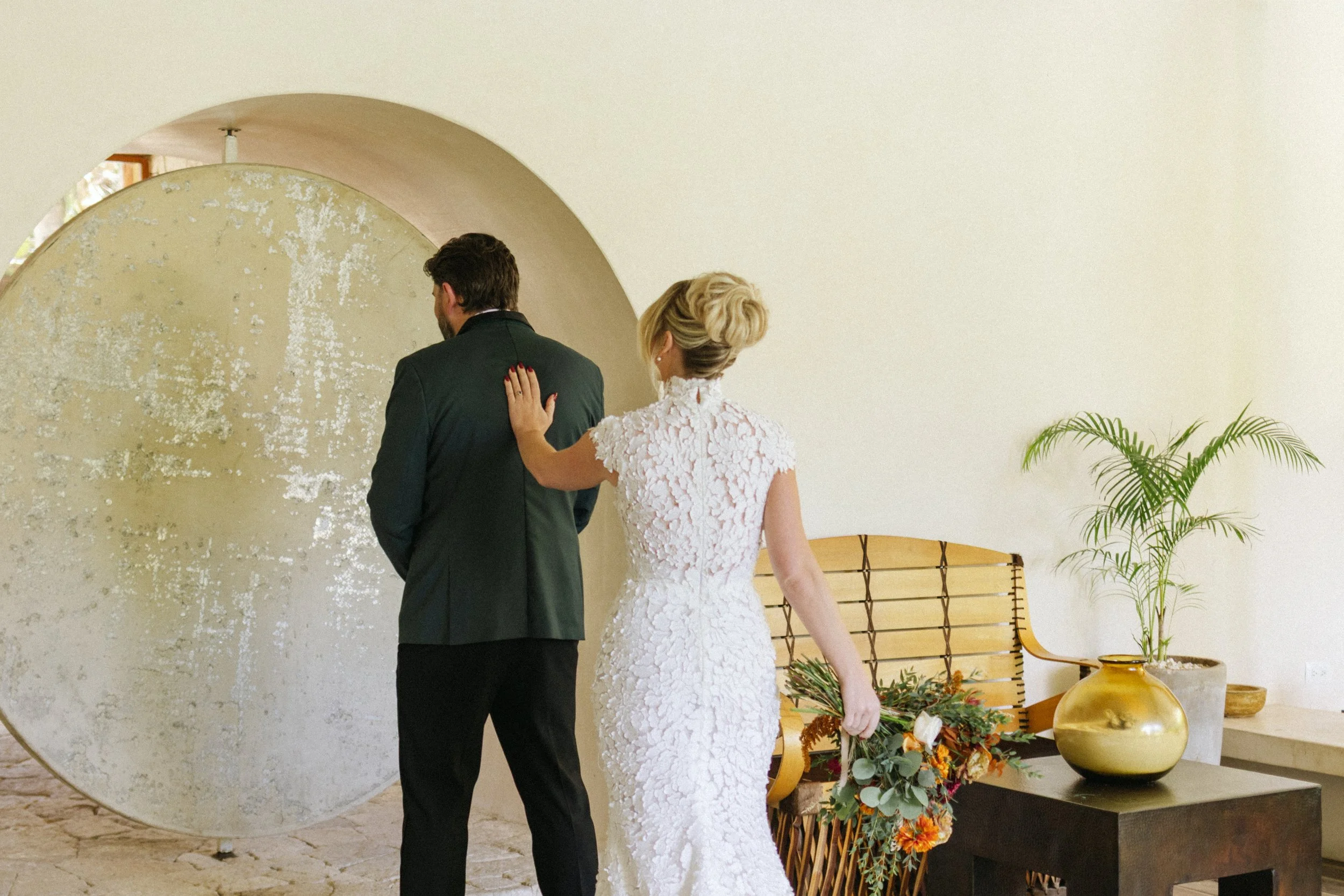 the first look at Vessica Tulum with the groom facing the rounded door and the bride touching his back to see her for the first time, an event photographer by von luebbert photo wedding photographer 