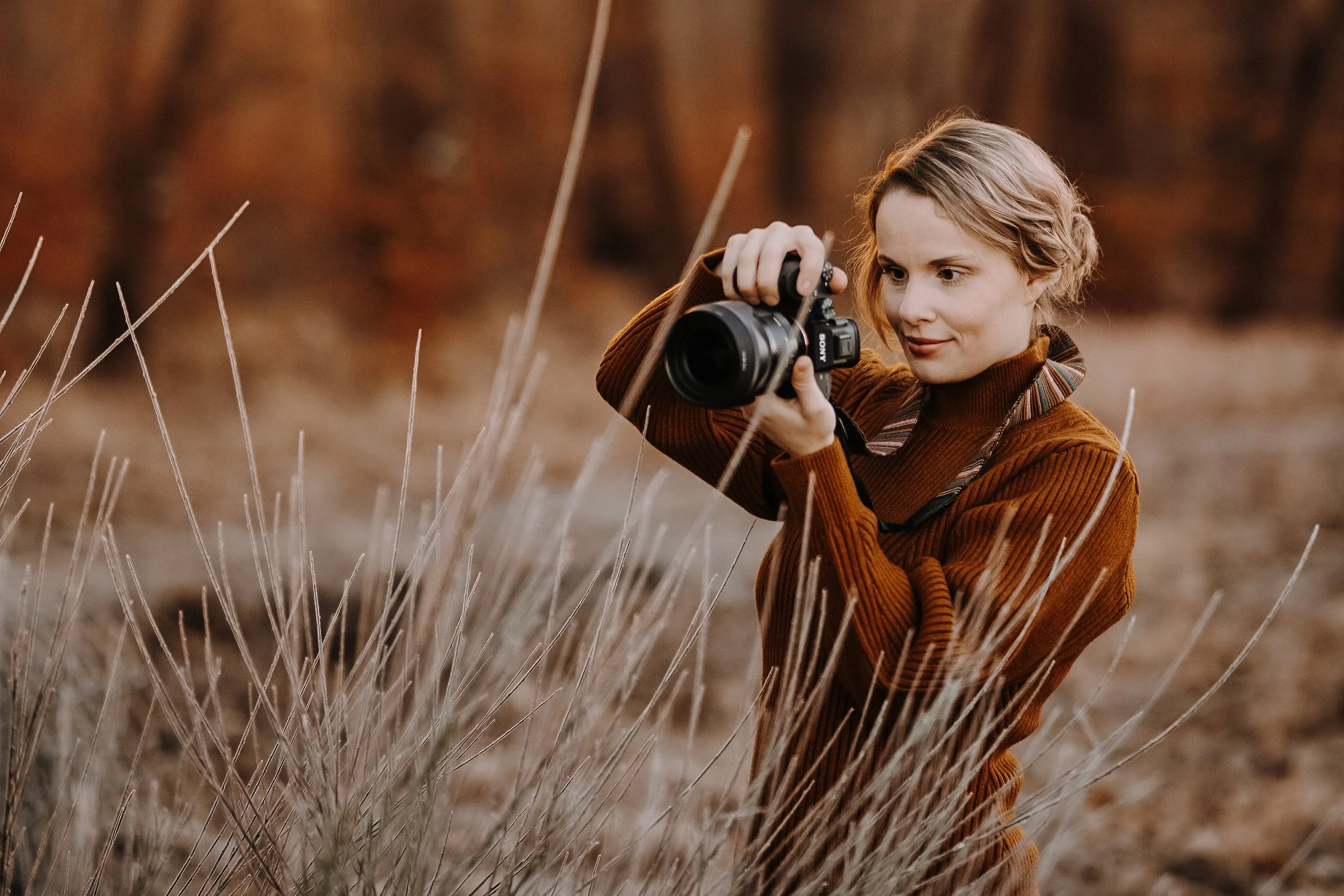 Blonde Frau fotografiert durch eine Pflanze