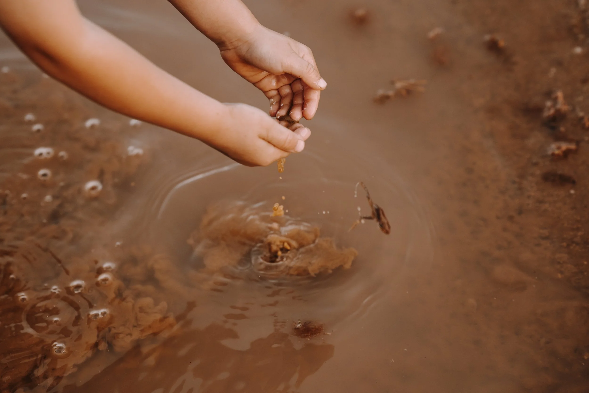 Kinder spielen am Meer, Wasser läuft über ihre Füße.