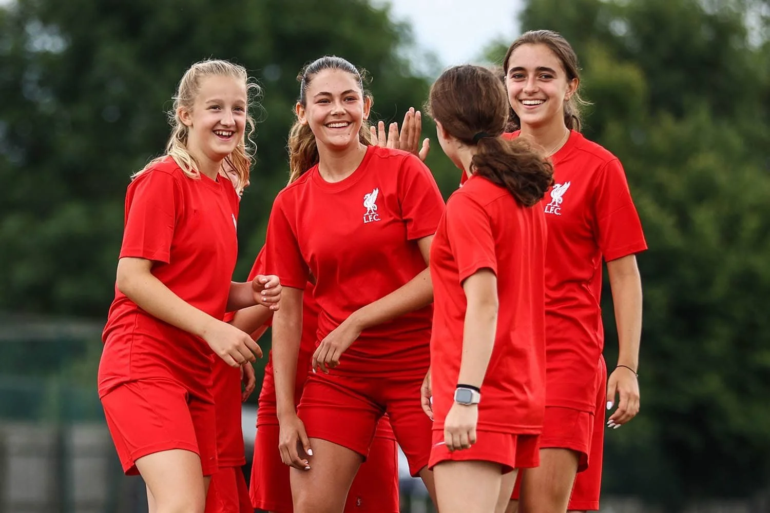 Girls celebrating goal on football camp in England