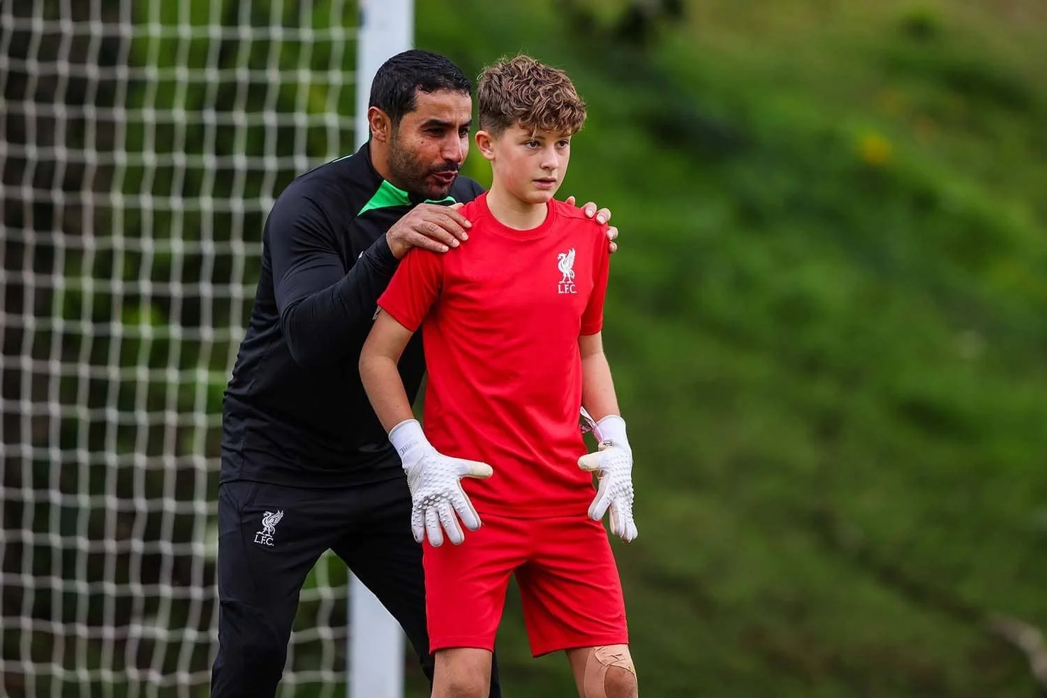 Liverpool FC coach helping goalkeeper on camp