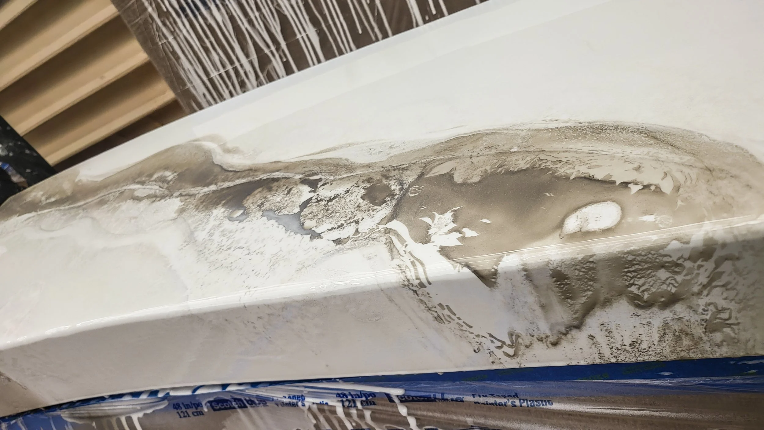 Close-up of a epoxy table top with gray and white marbled patterns.