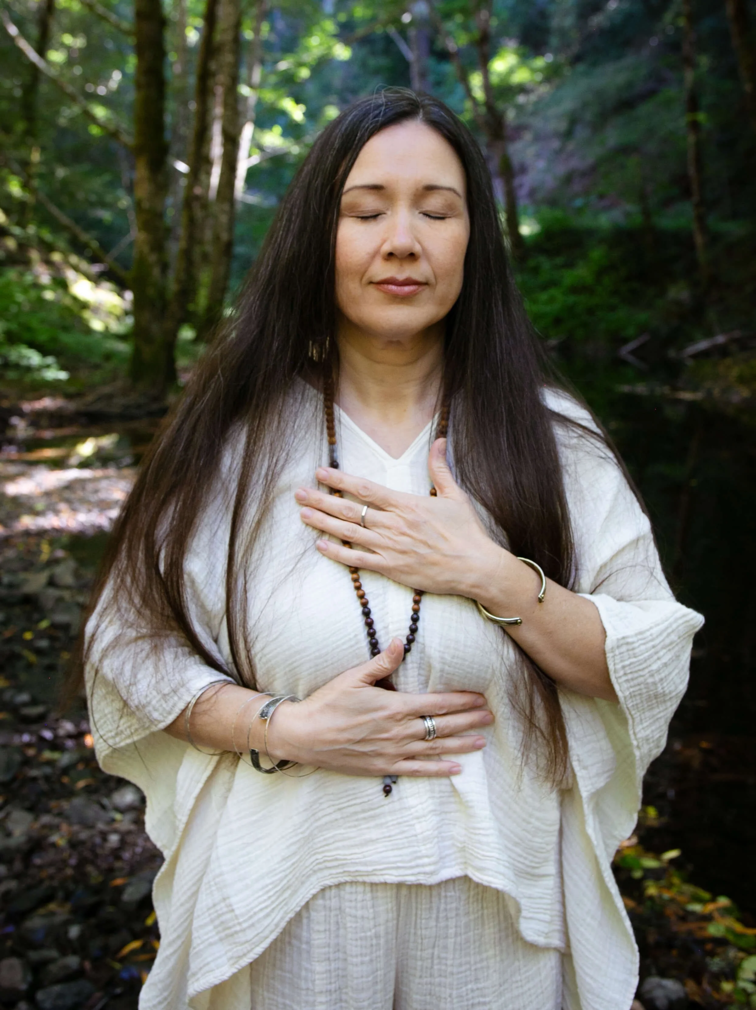 woman holding a hand on her heart and belly