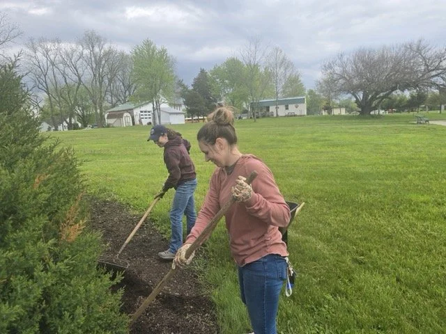 Two IPT staff members using rakes while landscaping at Huntertown Family Park