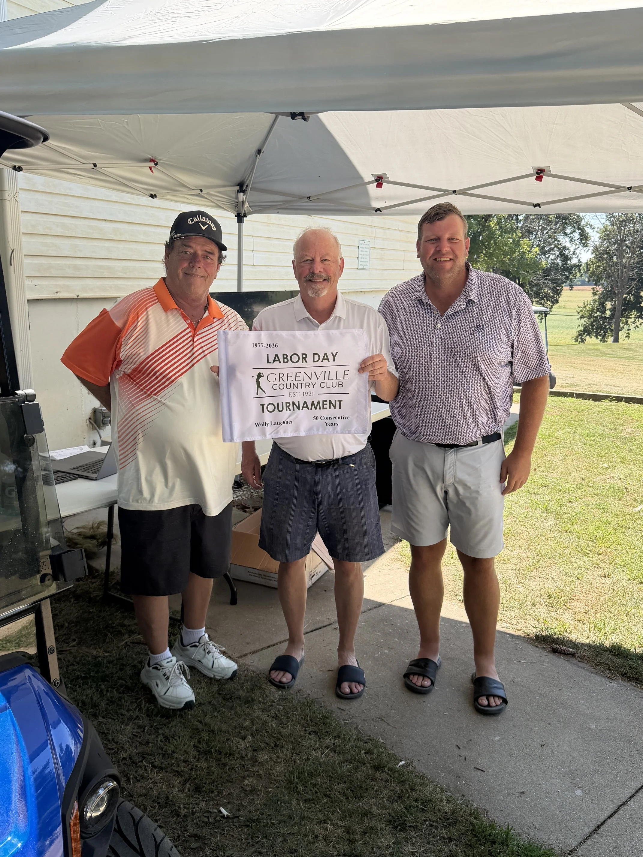 Wally Lauchner (C) holding his commemorative flag for his 50th consecutive Labor Day Championship appearance - GCC President Gene Kious (L), Tournament Director Steve Rommerskirchen (R)