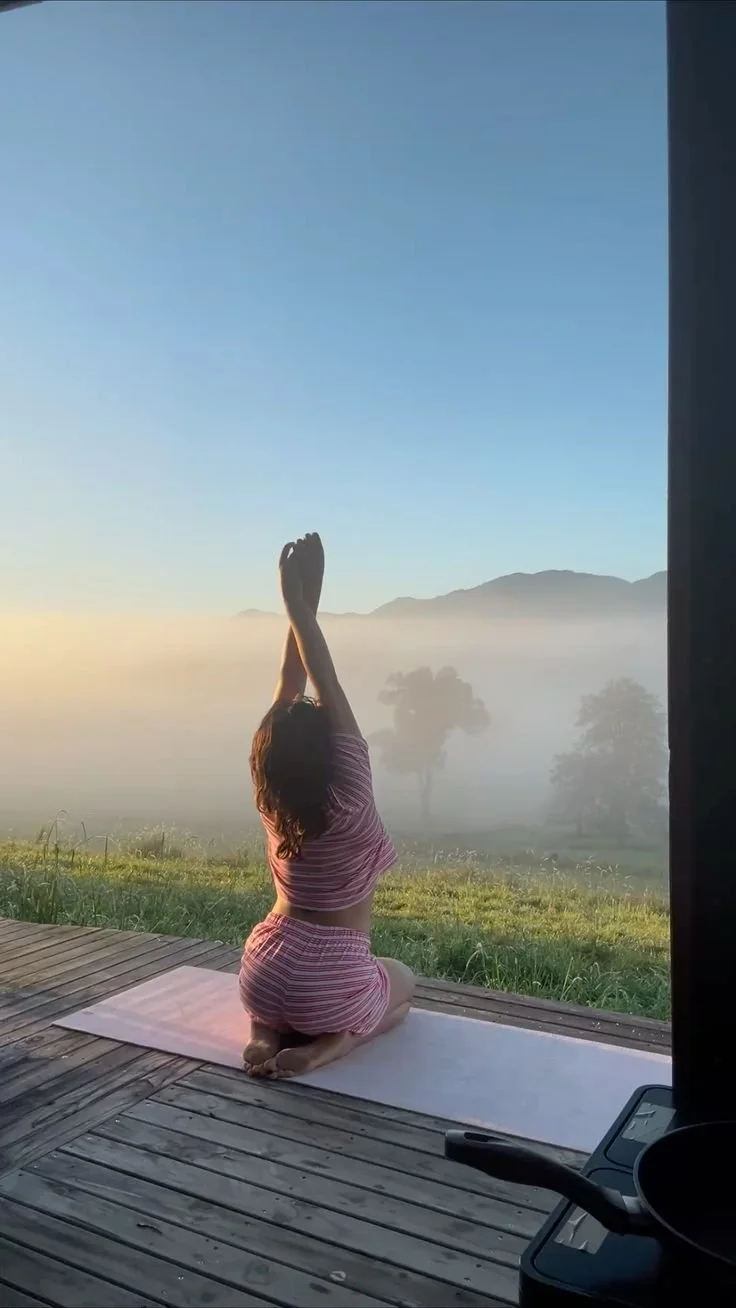 Femme faisant du yoga en position de respiration avec vue sur la nature et le matin