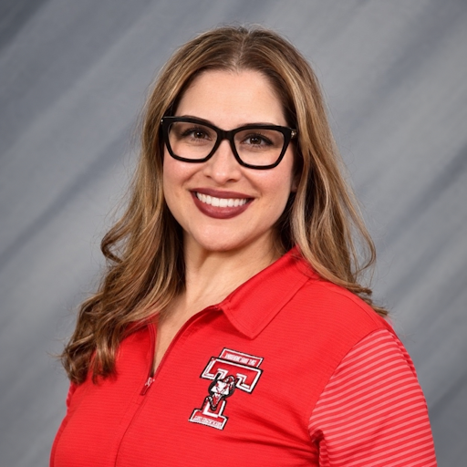 Woman wearing red shirt smiling at camera