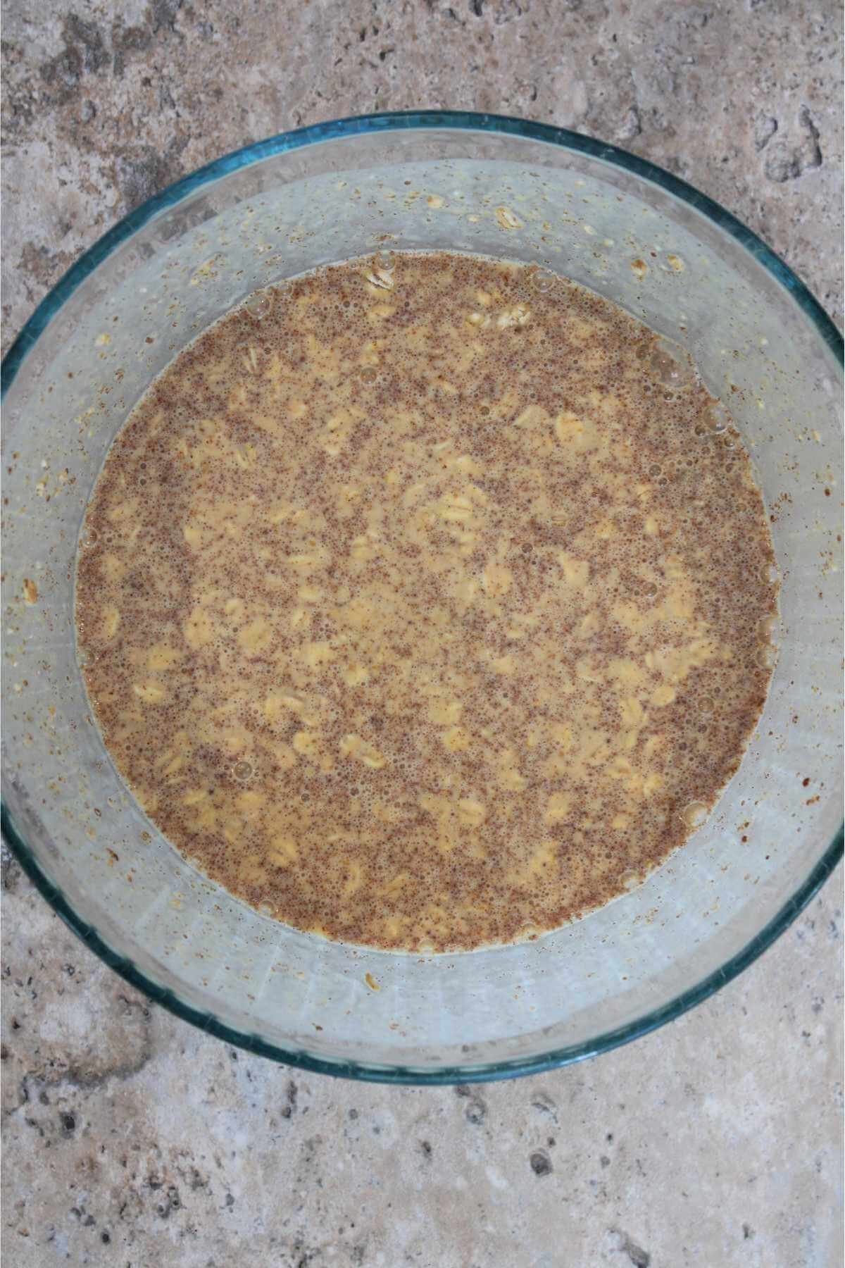 A mixing bowl full of pumpkin overnight oatmeal ingredients being mixed together.