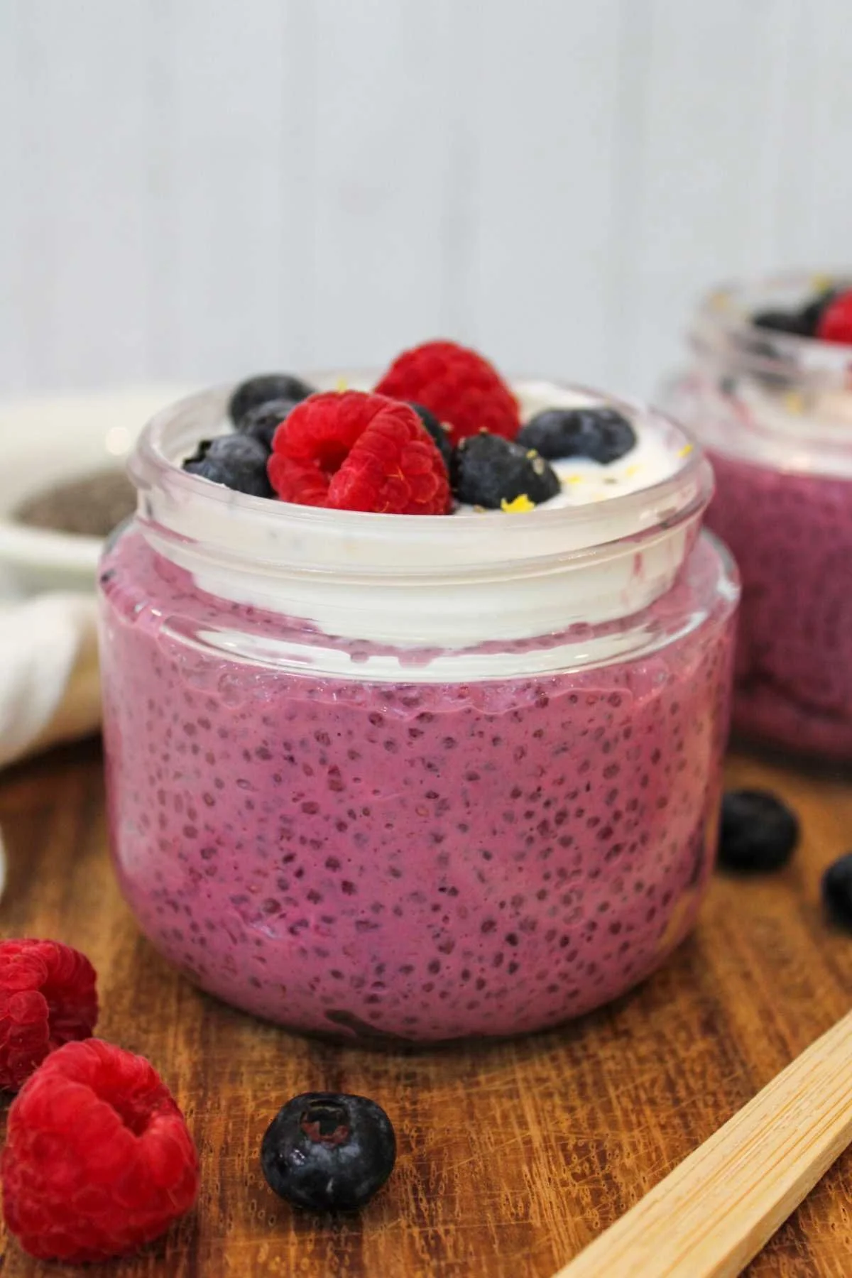Purple chia seed pudding recipe topped with yogurt and fresh berries.