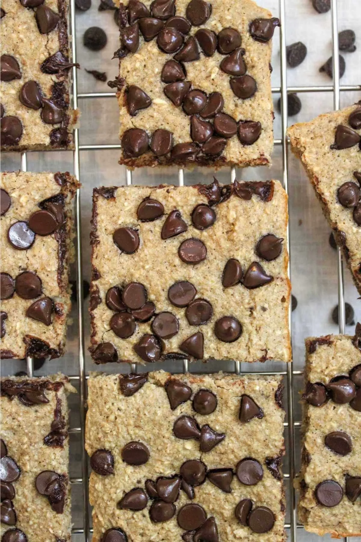 Baked oatmeal bars topped heavily with chocolate chips, sliced into squares, and served on a wire rack.