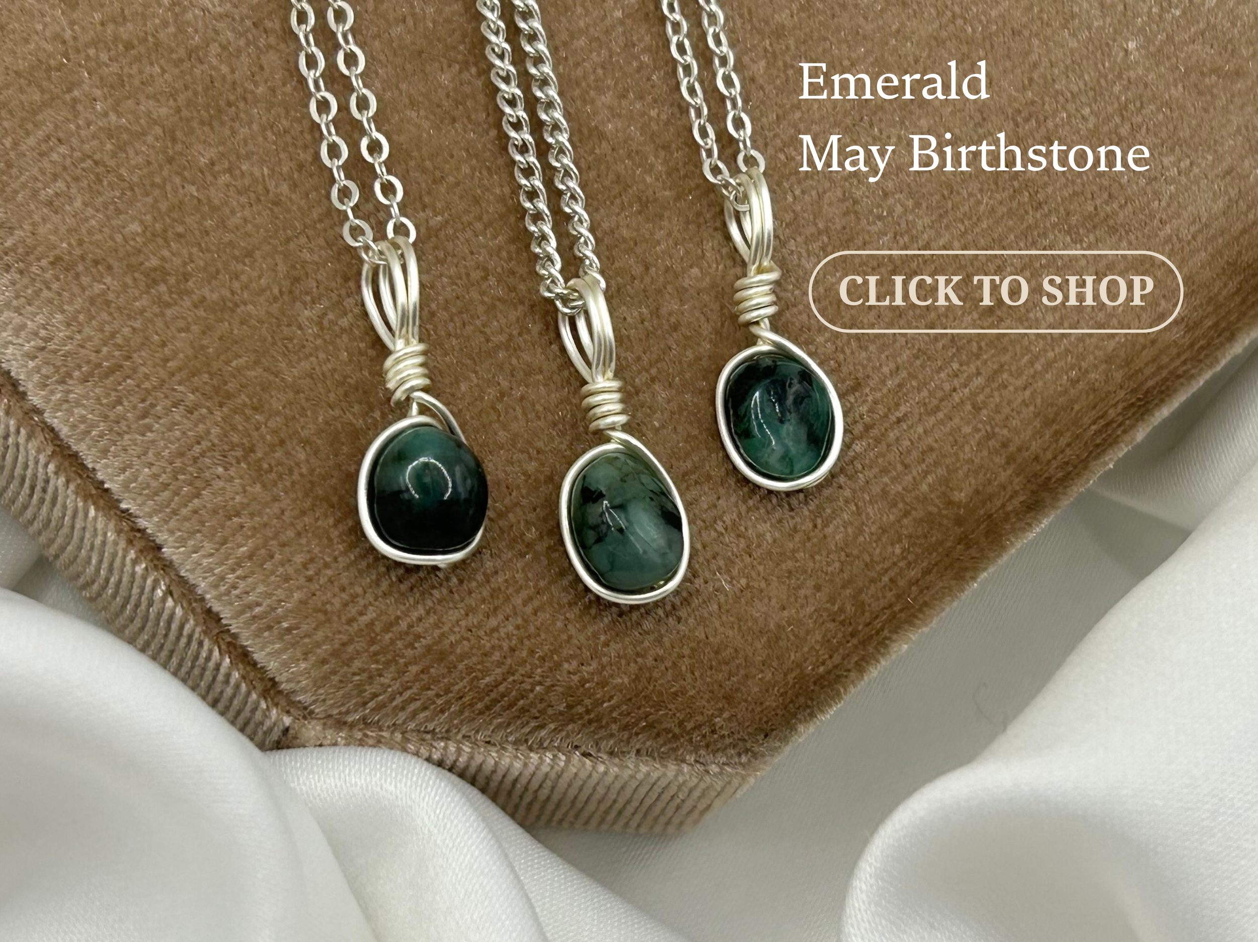 Three silver necklaces with oval green gemstone pendants displayed on a brown fabric background.