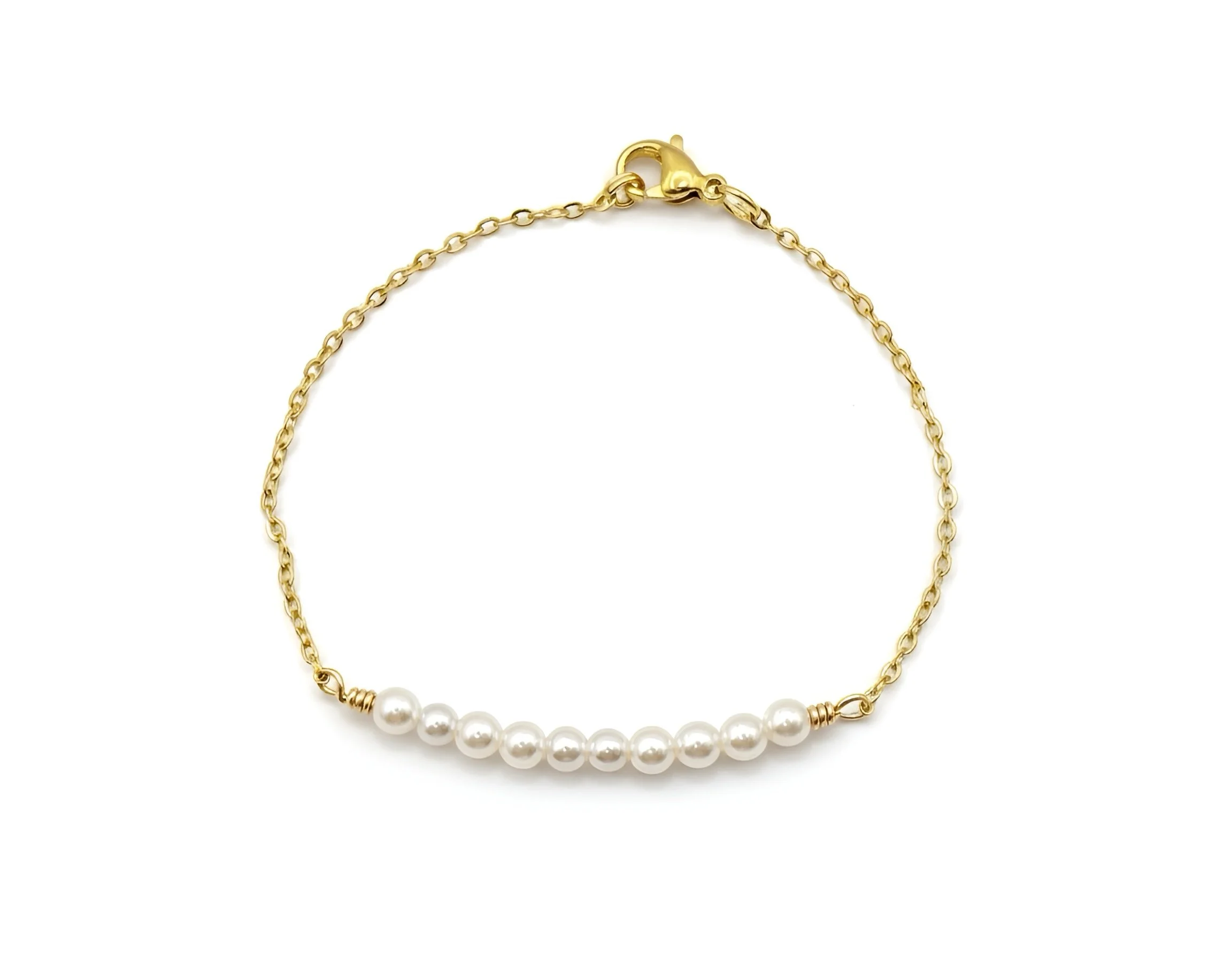 Two beaded bracelets on wrist, gold and one silver, with amber beads.