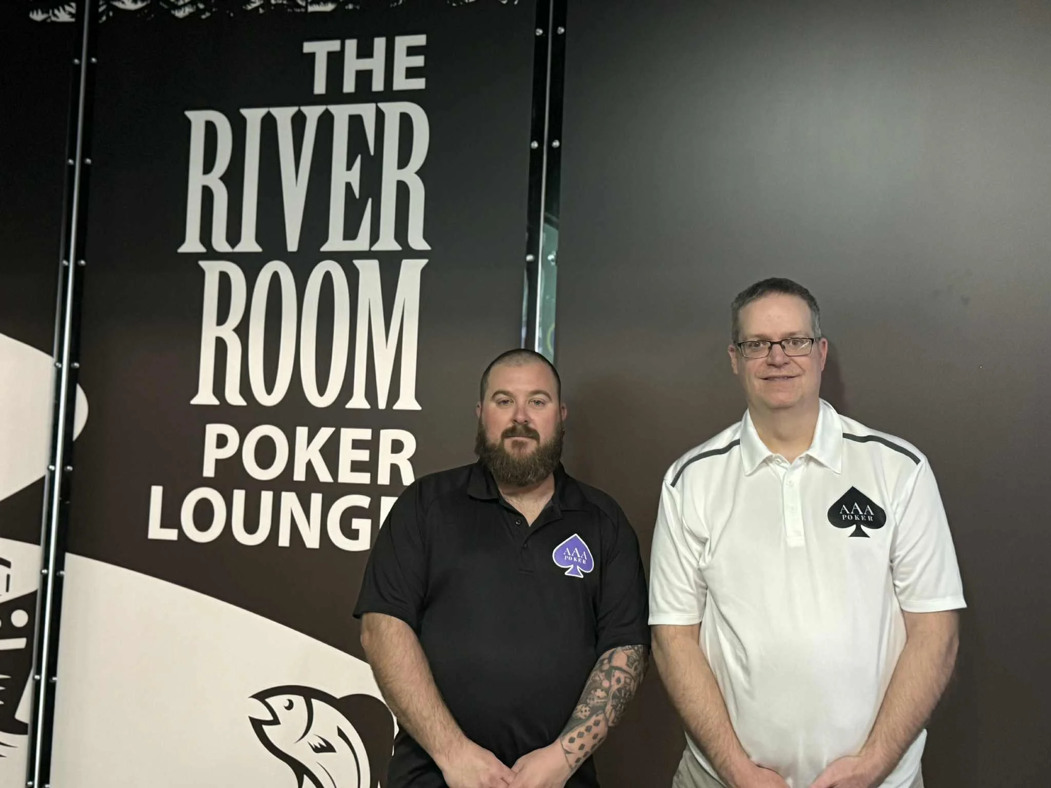 Trip Aces Poker Tour Joe and Tyler standing in front of a black and white sign that reads 'The River Poker Lounge'.