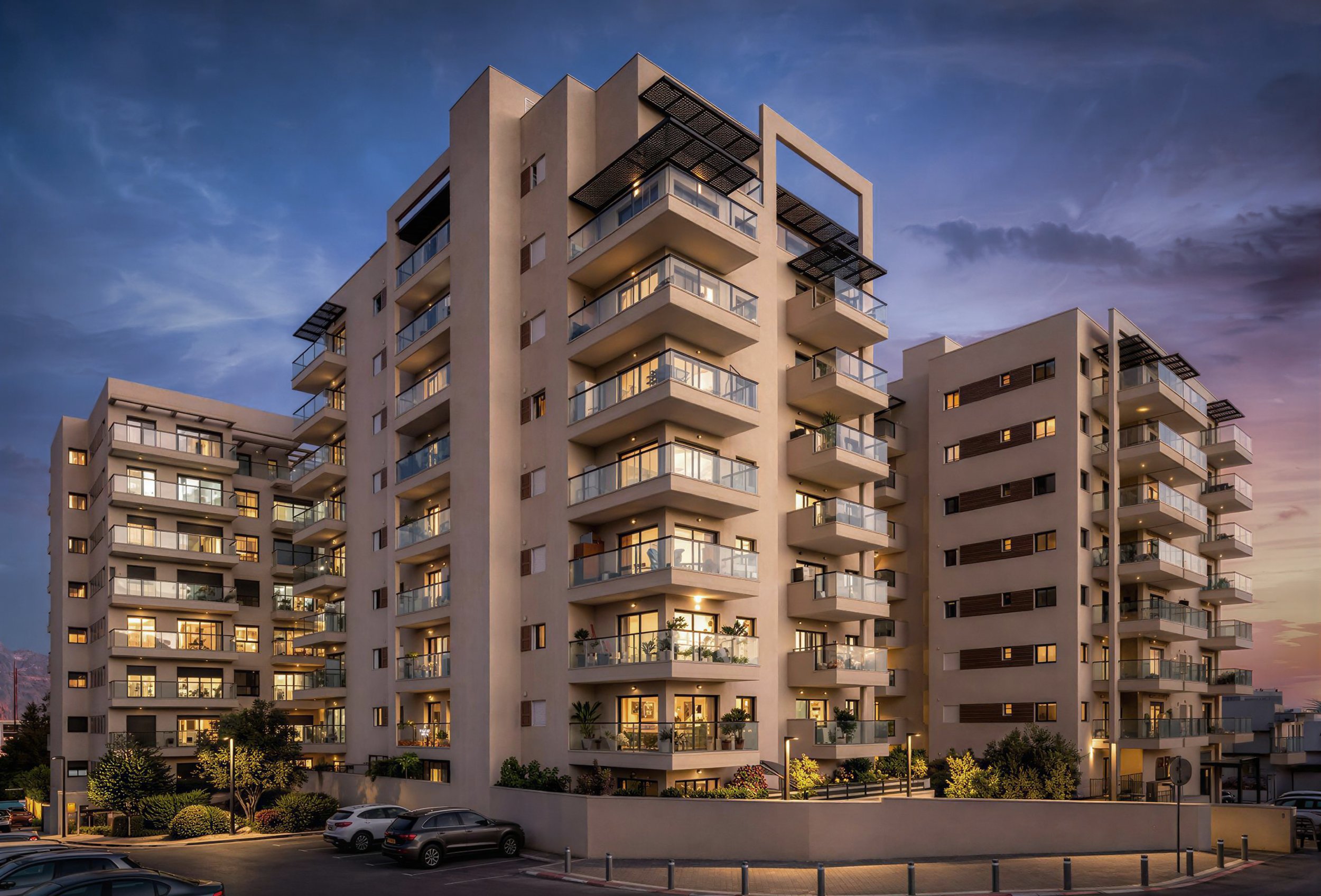 Modern multi-story apartment building with balconies, illuminated windows, and surrounding parking lot at dusk.