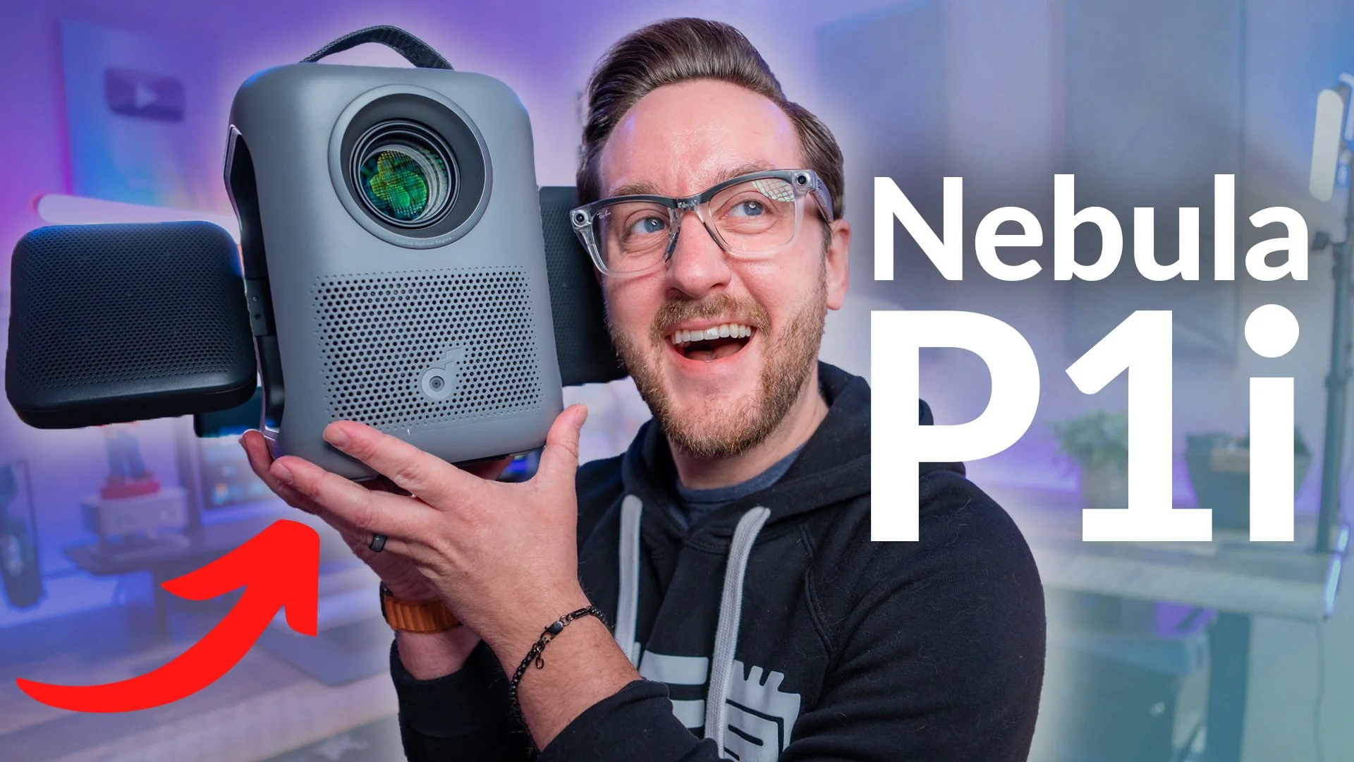 A man smiling and holding a Nebula D1 Pi projector close to his face, with a colorful tech-inspired background.