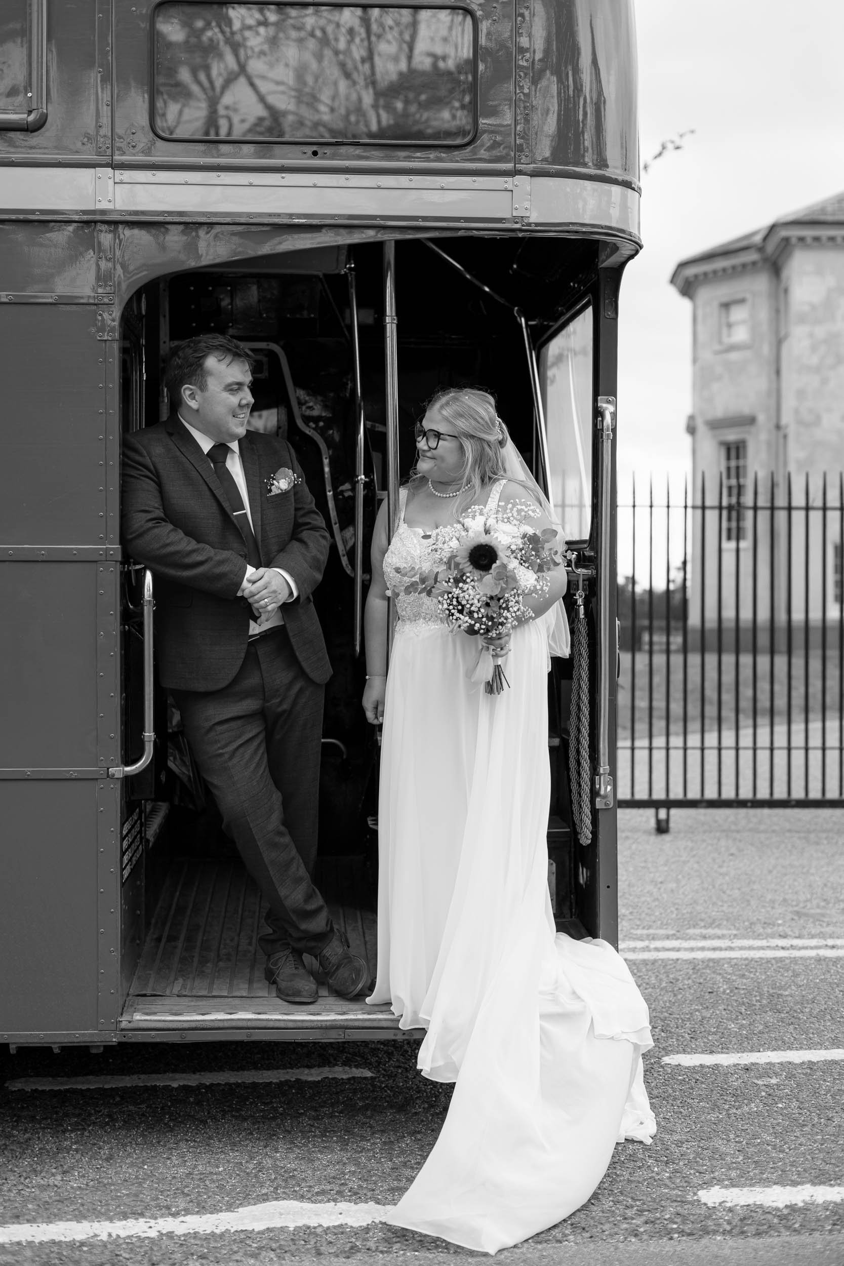 Bride and Groom on classic bus looking at each other