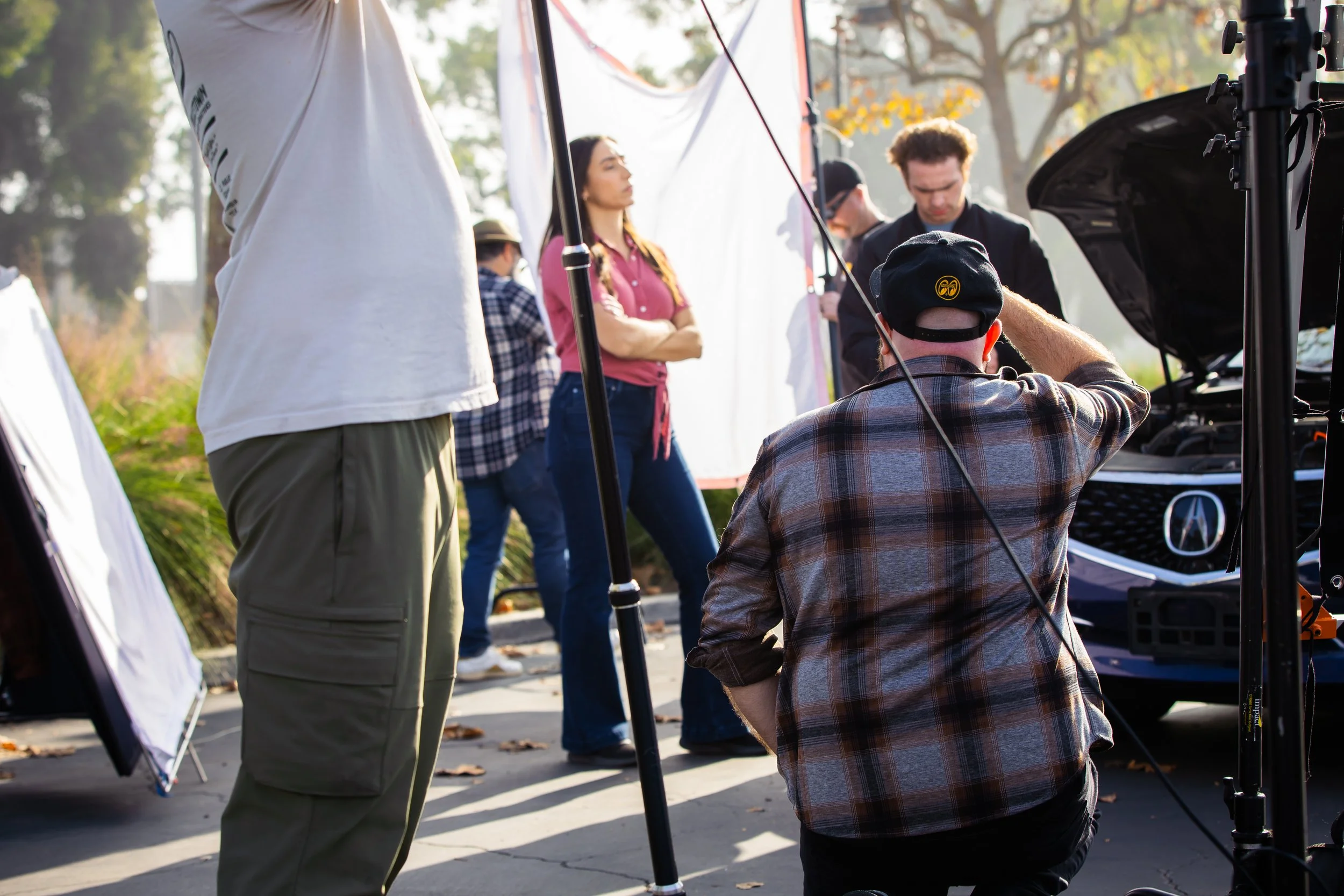 A director kneels down on a set with two actors.