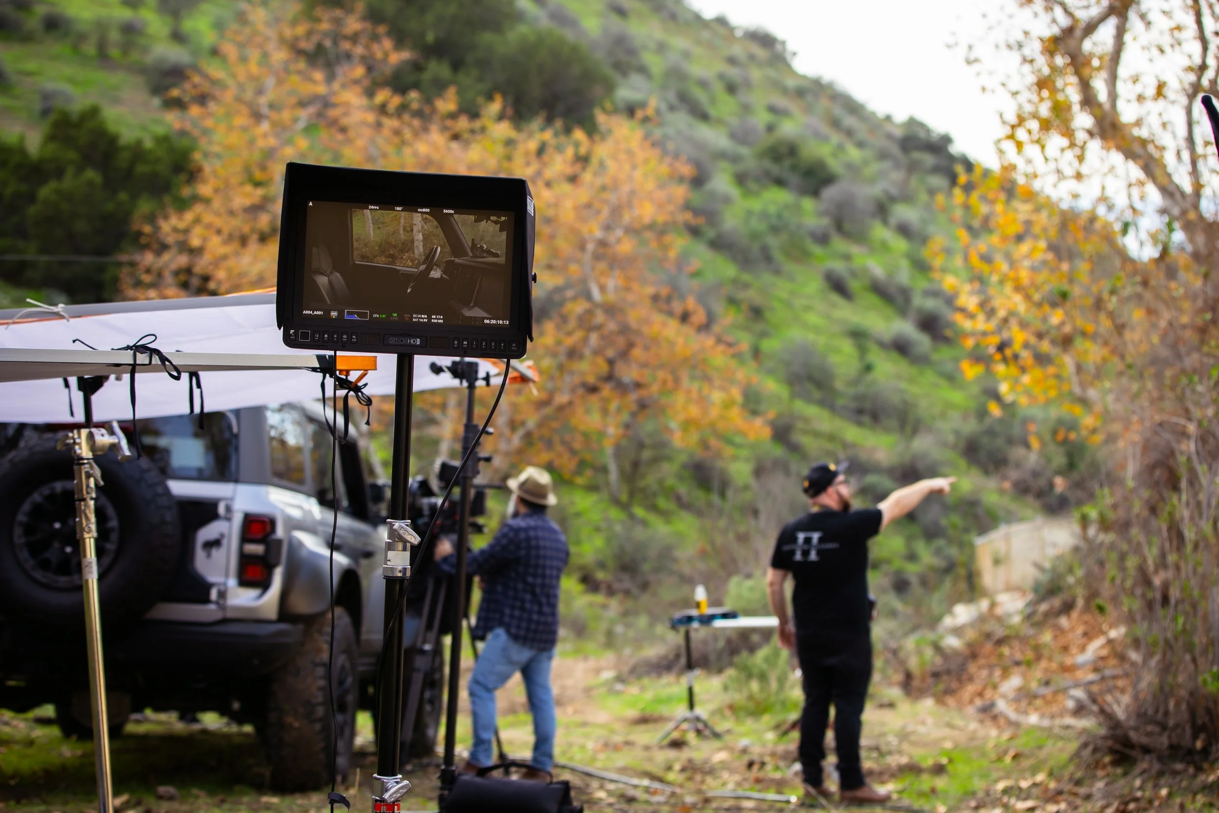 A monitor shows a shot that is being prepped for a commercial being filmed in the woods.