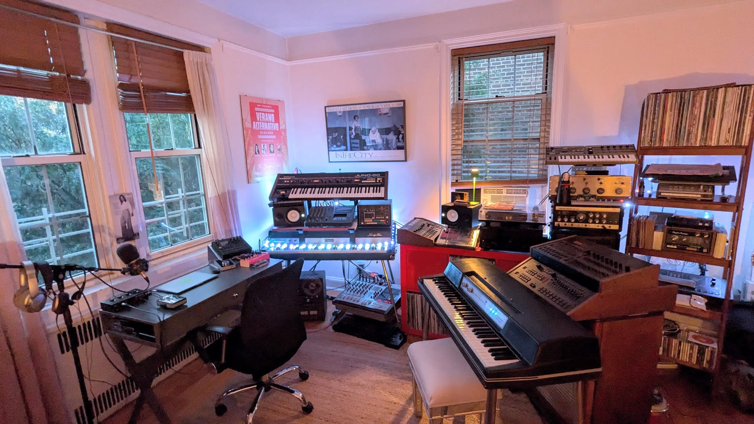 La escritora Mariana Enriquez sentada en un sofá rojo al lado de la entrevistadora Eugenia Zicavo en un cuarto donde son entrevistadas, se ve un banner de la FILNYC, equipo de video y un fotógrafo operando una cámara.