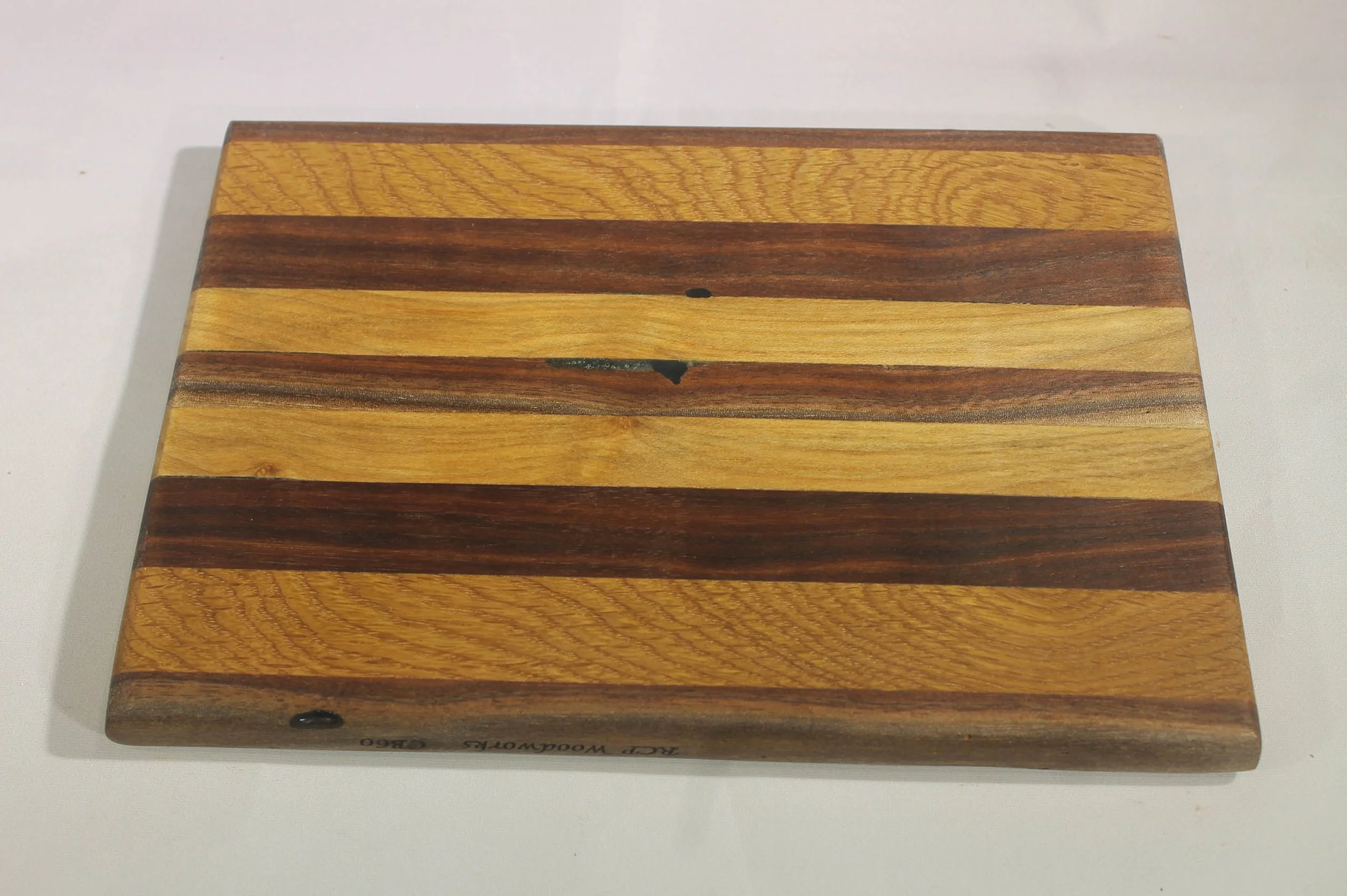 CB58  -  Cutting Board                    $55

7” wide by 13” long by 5/8” thick.
Seven segments of wood – Maple, Oak, Maple, Sweet Gum, Maple, Oak, Maple

Finished with cutting board oil.

