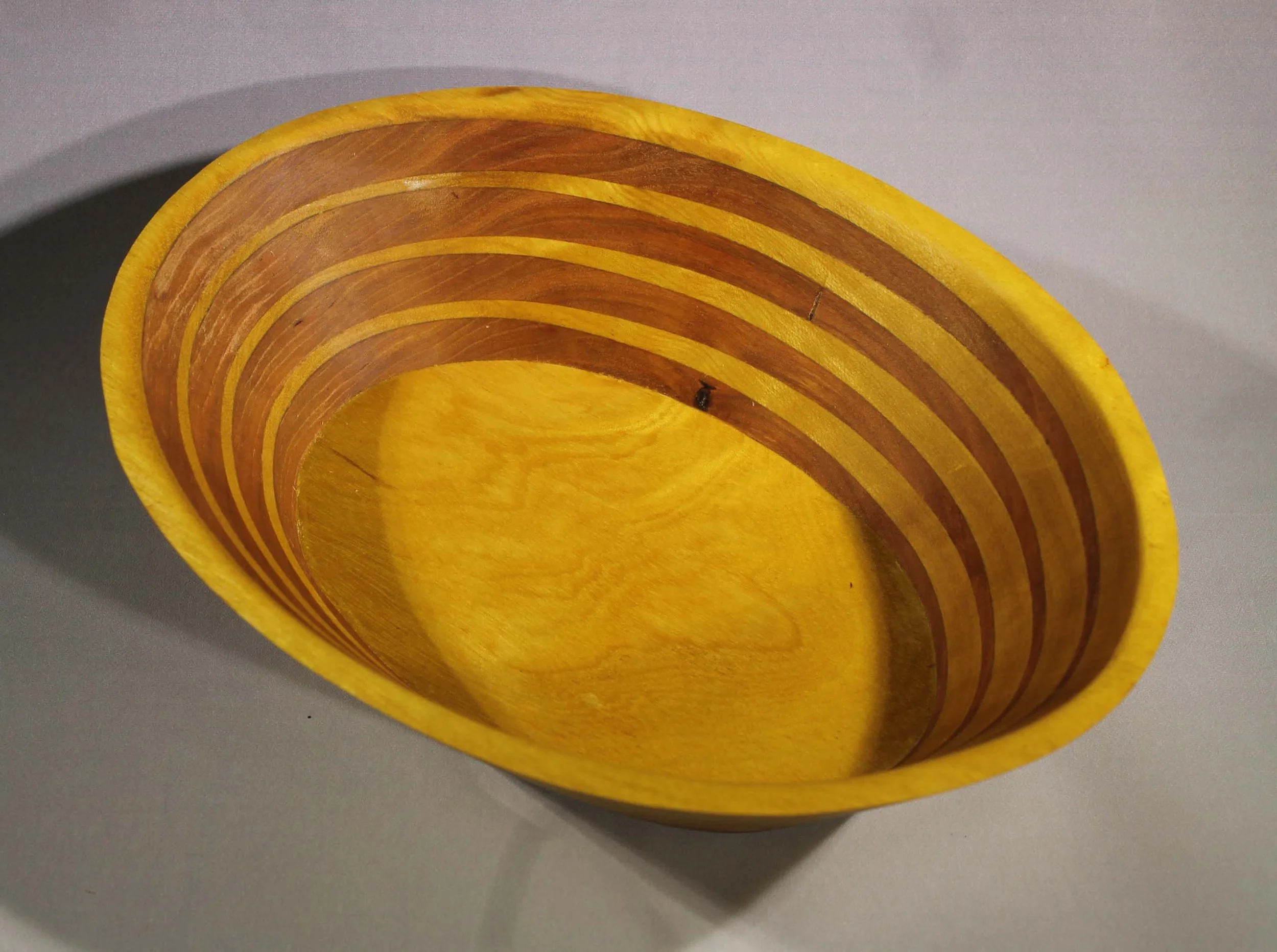 #6351 - Cherry / Osage Orange Oval Wedge Bowl
This is my signature wedge design with Osage Orange and Cherry woods.     The wedge effect gives this bowl character.  The colors of this bowl are light and airy.  You can see the grain of the bottom of b