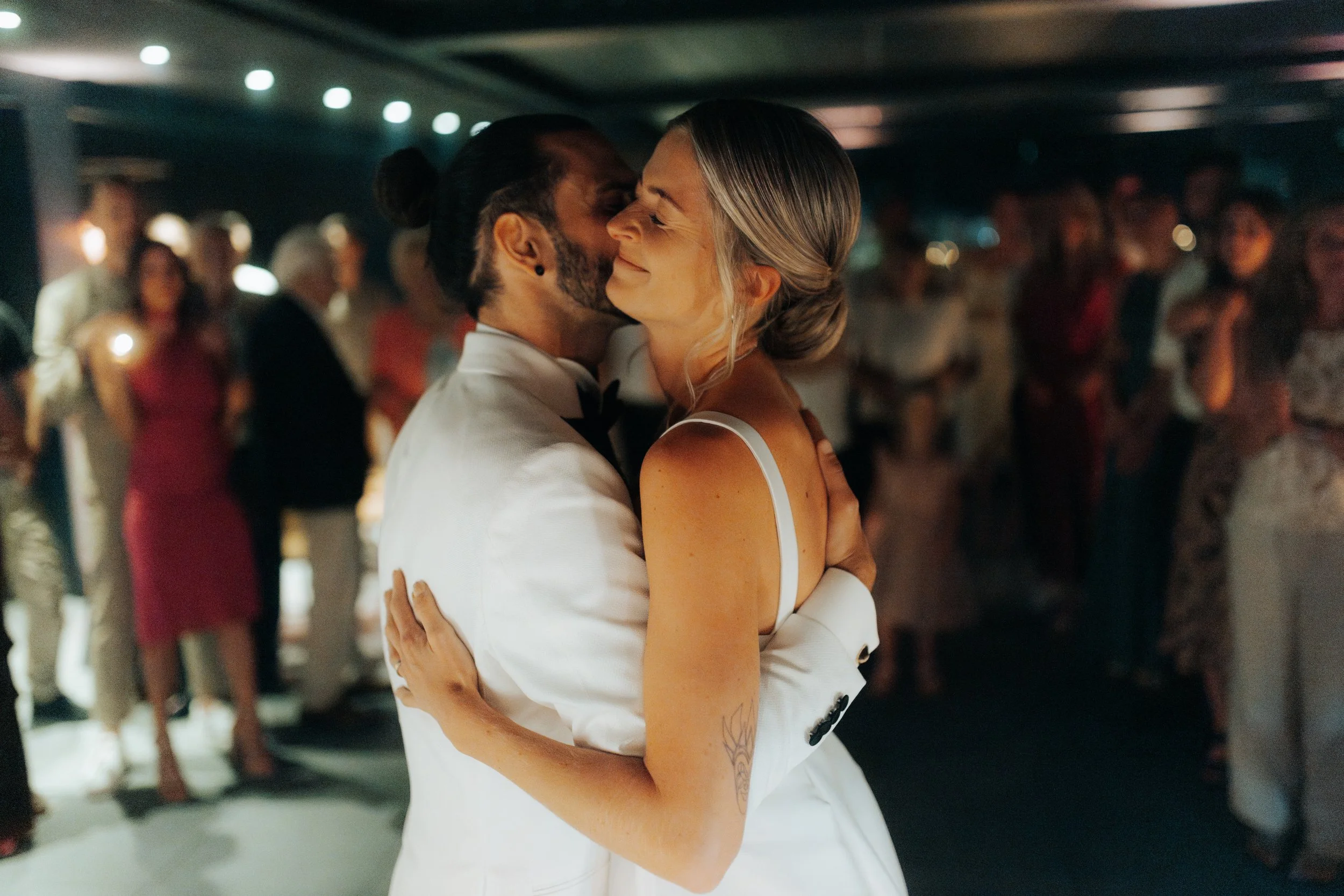 Ein tanzendes Paar bei einer Hochzeit, umgeben von Gästen.